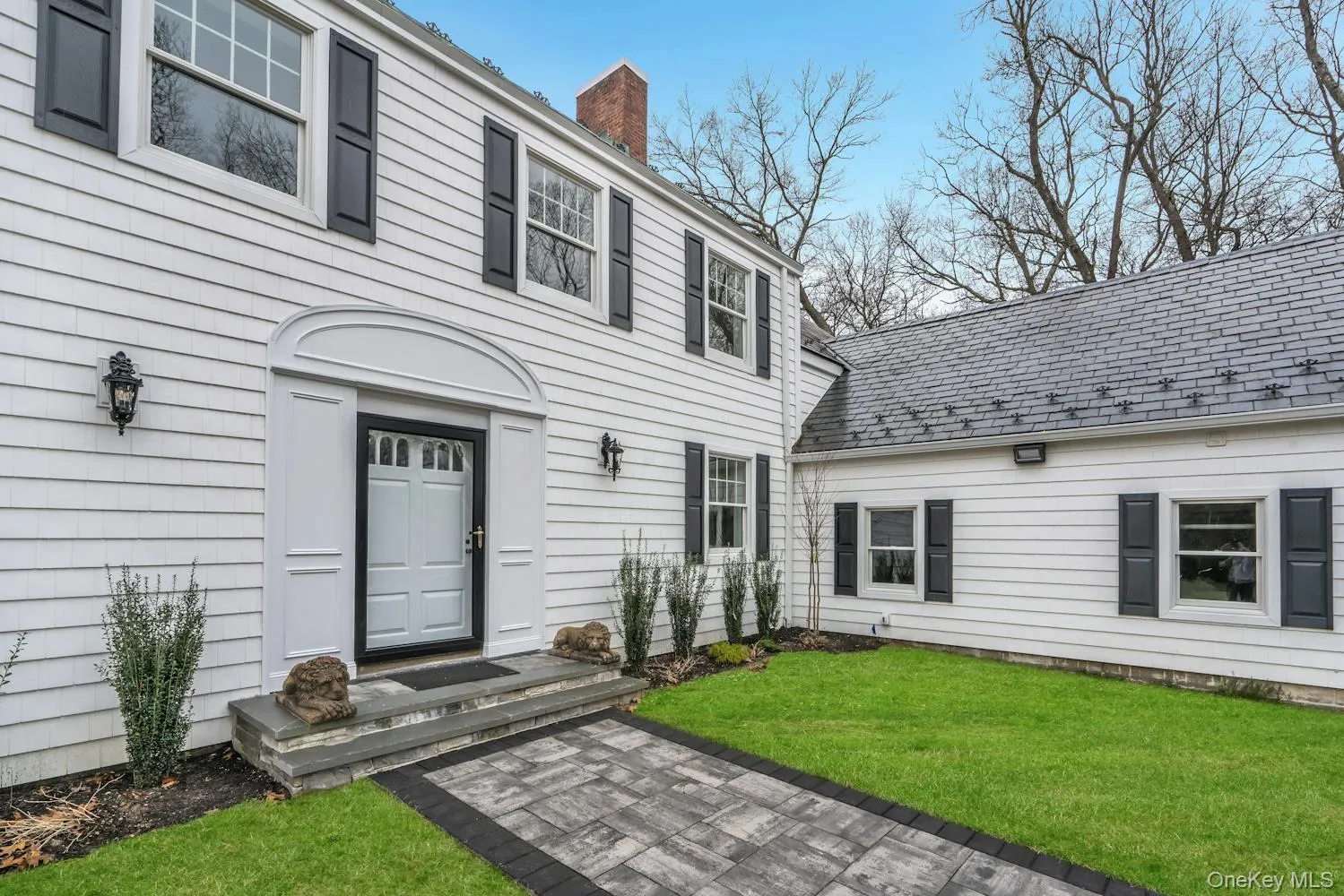 Property entrance featuring a yard and a chimney Property entrance featuring a yard and a chimney