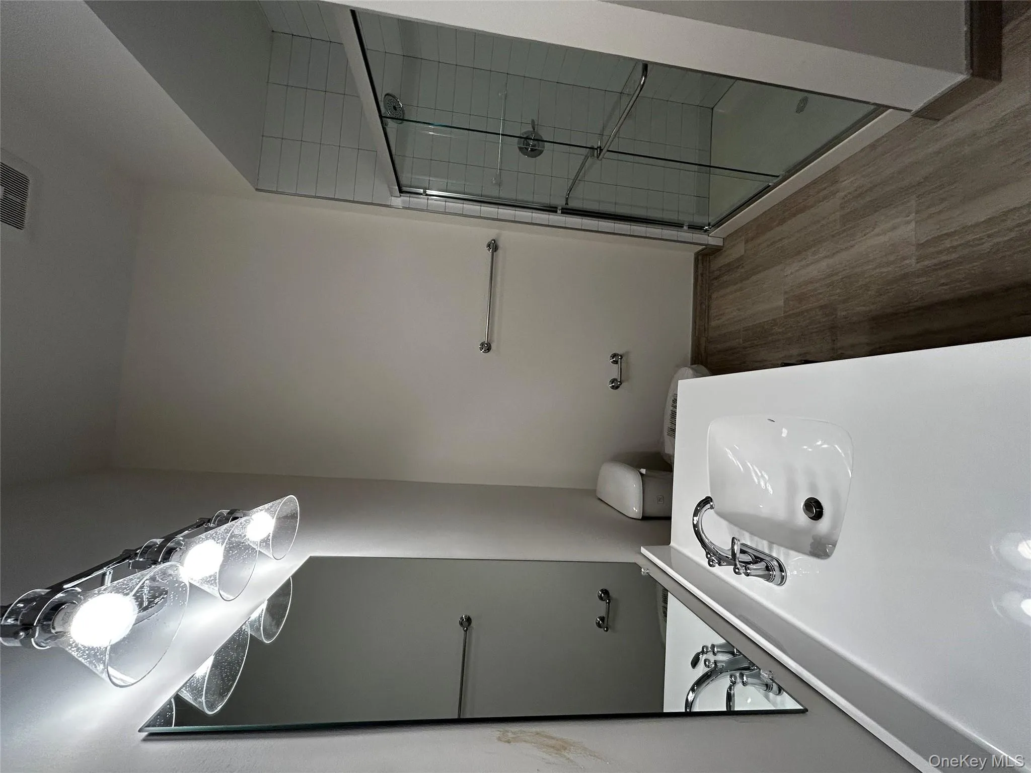 Full bath with visible vents, vanity, wood finished floors, toilet, and a shower stall Full bath with visible vents, vanity, wood finished floors, toilet, and a shower stall