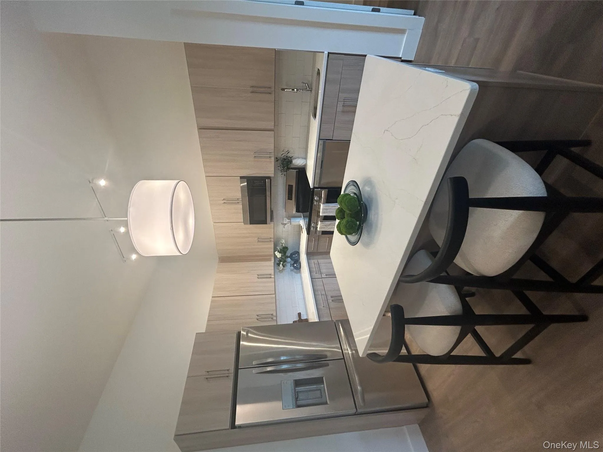 Kitchen with stainless steel appliances, dark wood-style floors, pendant lighting, and a kitchen island Kitchen with stainless steel appliances, dark wood-style floors, pendant lighting, and a kitchen island