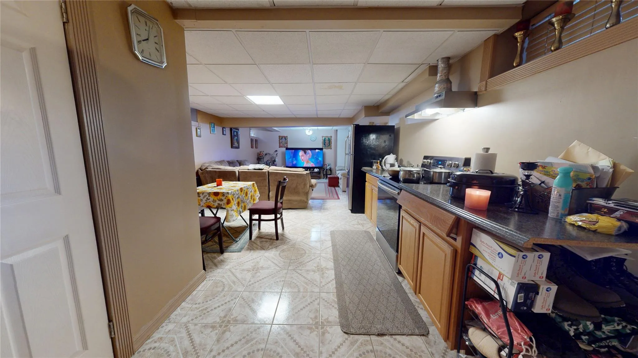 Kitchen featuring dark countertops, a paneled ceiling, brown cabinetry, and stainless steel range with electric cooktop Kitchen featuring dark countertops, a paneled ceiling, brown cabinetry, and stainless steel range with electric cooktop