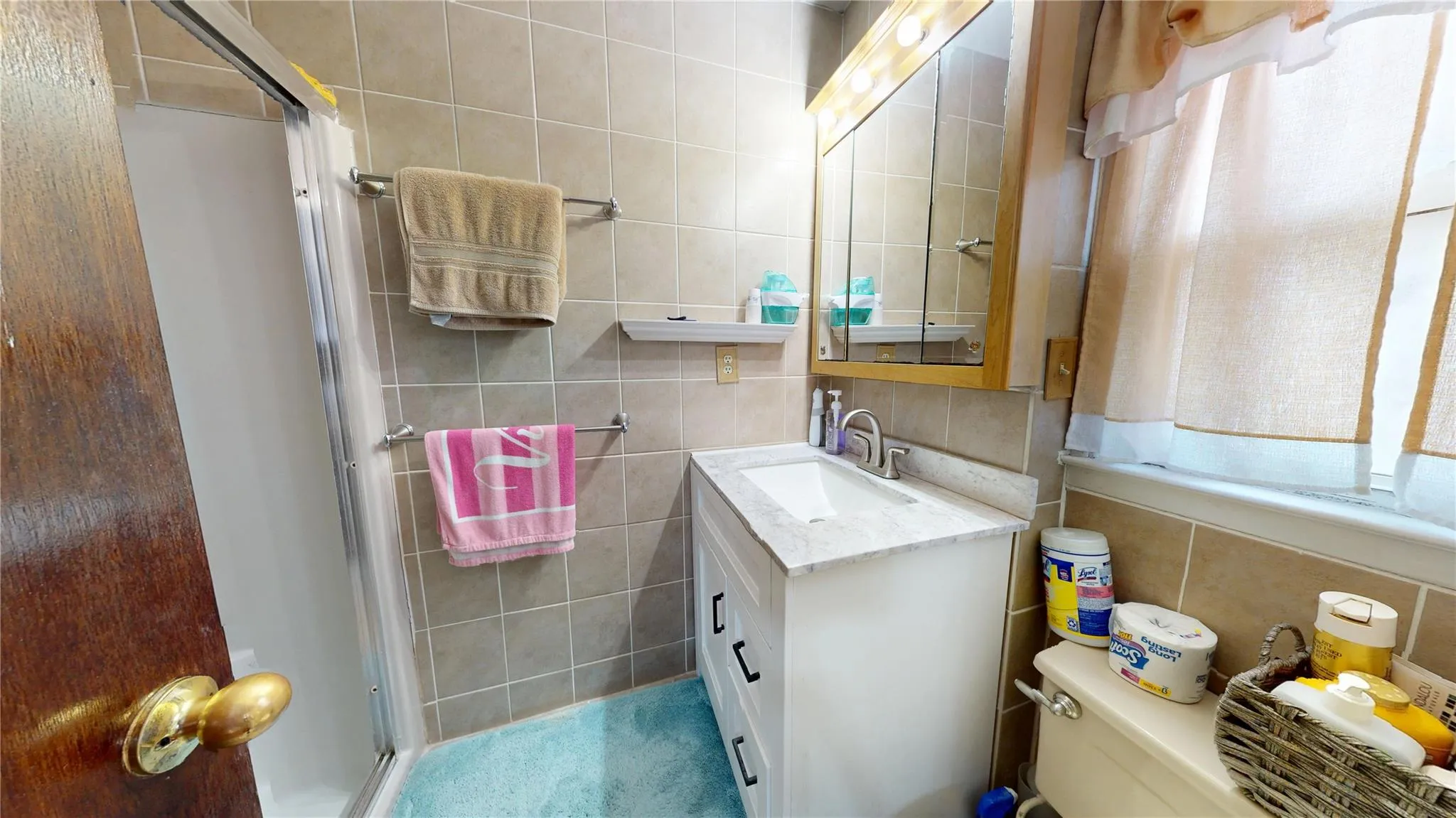 Bathroom featuring tile walls, a stall shower, and vanity Bathroom featuring tile walls, a stall shower, and vanity