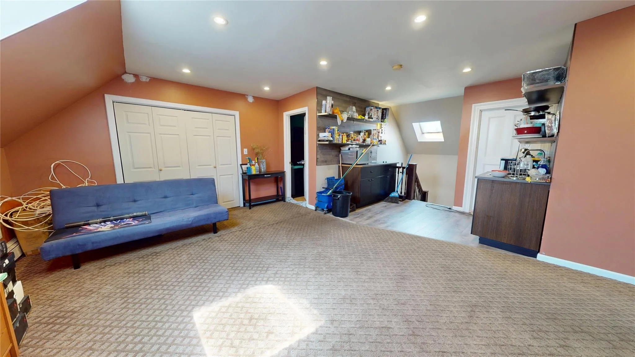 Living area featuring lofted ceiling with skylight, wood finished floors, recessed lighting, and baseboards Living area featuring lofted ceiling with skylight, wood finished floors, recessed lighting, and baseboards
