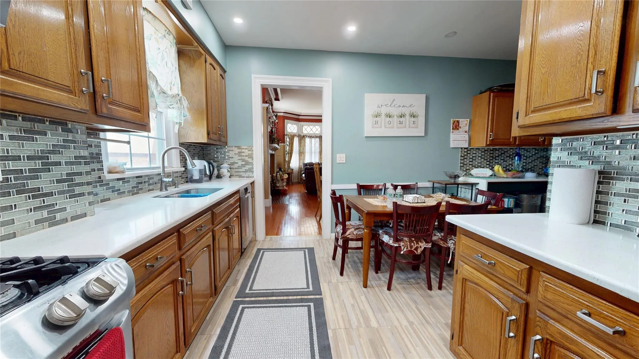 Kitchen with brown cabinetry, tasteful backsplash, gas stove, and a sink Kitchen with brown cabinetry, tasteful backsplash, gas stove, and a sink
