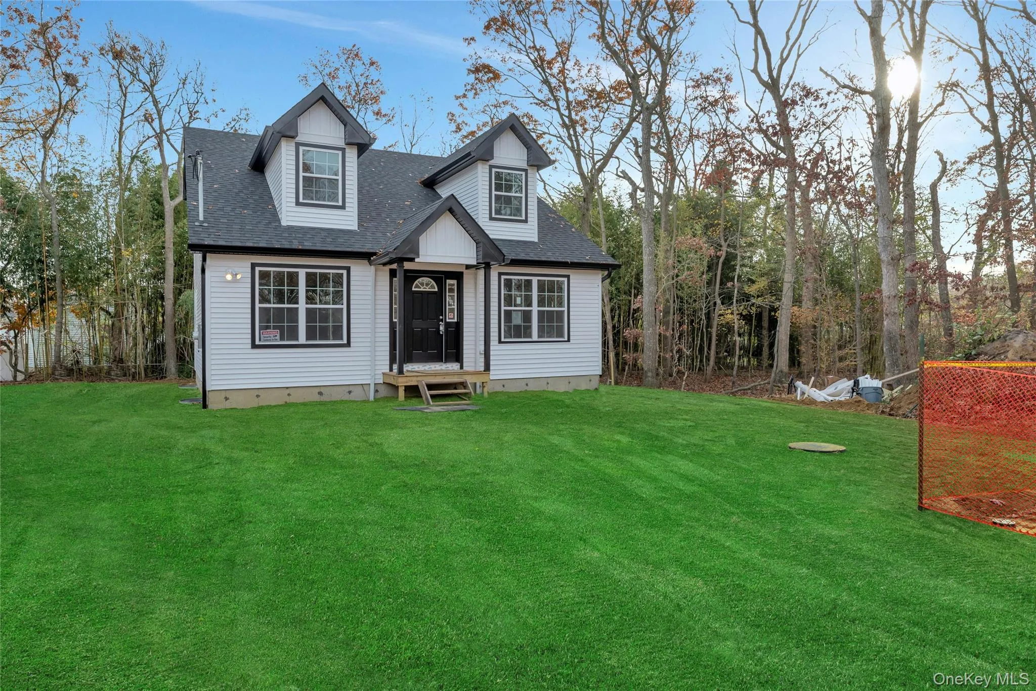 Cape cod-style house featuring a shingled roof and a front lawn Cape cod-style house featuring a shingled roof and a front lawn