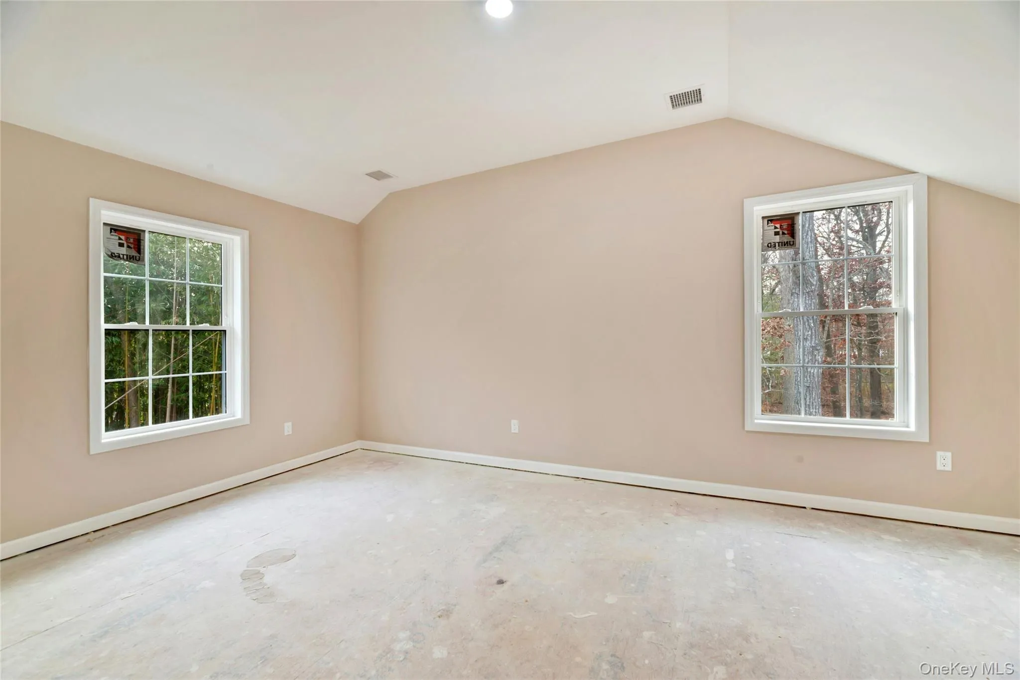 Spare room featuring baseboards and lofted ceiling Spare room featuring baseboards and lofted ceiling