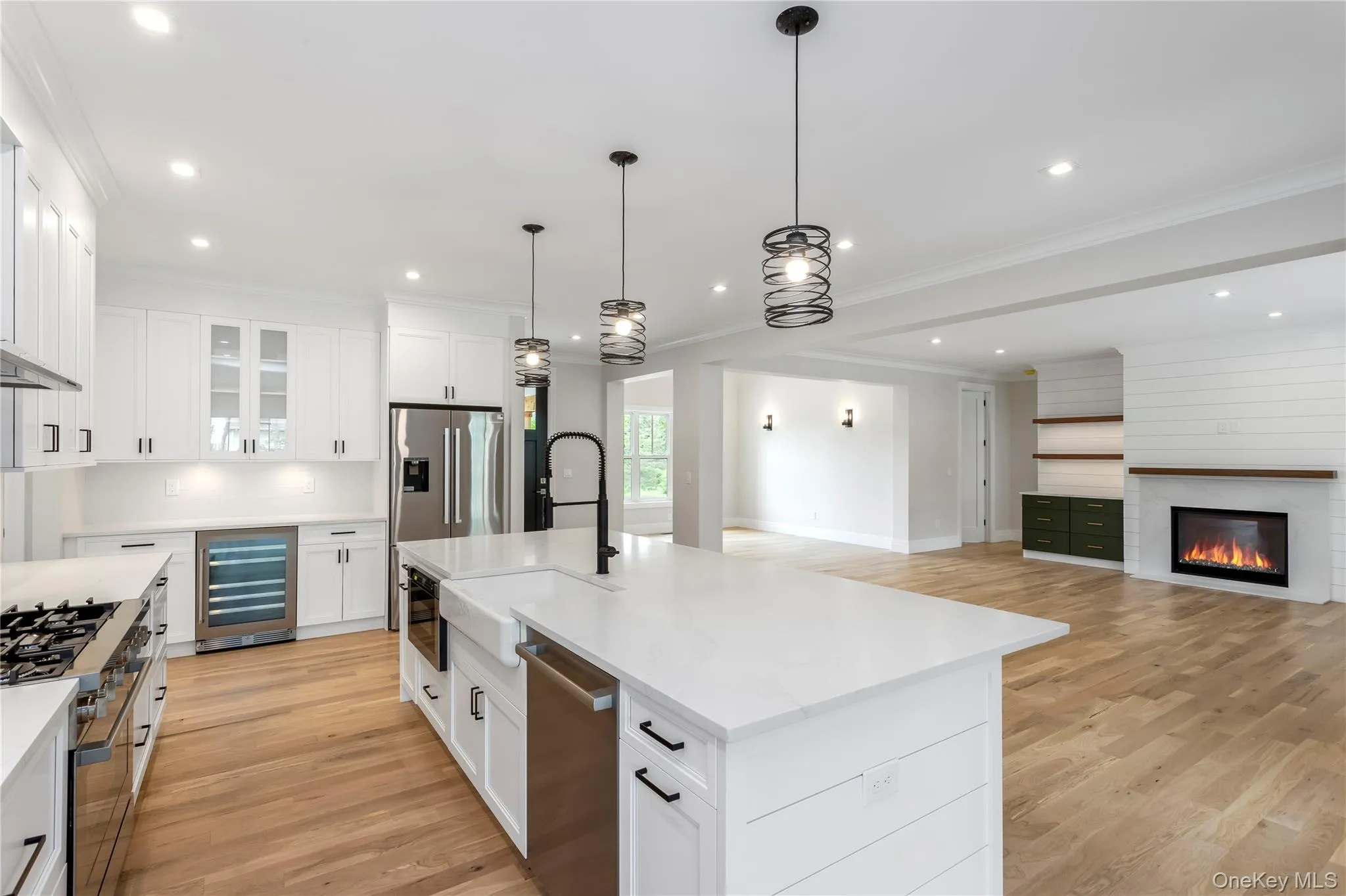 Kitchen featuring beverage cooler, appliances with stainless steel finishes, a sink, light wood-style floors, and recessed lighting Kitchen featuring beverage cooler, appliances with stainless steel finishes, a sink, light wood-style floors, and recessed lighting