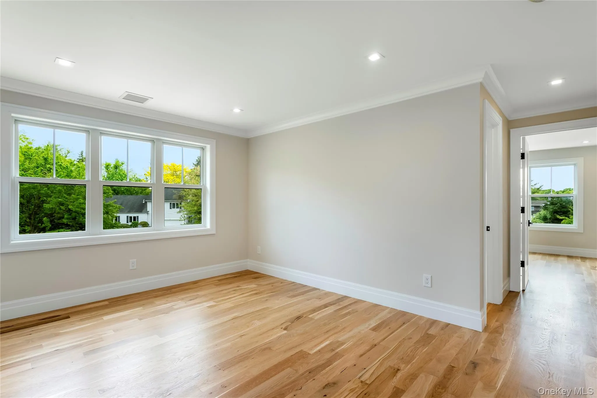 Spare room with crown molding, baseboards, light wood finished floors, and recessed lighting Spare room with crown molding, baseboards, light wood finished floors, and recessed lighting