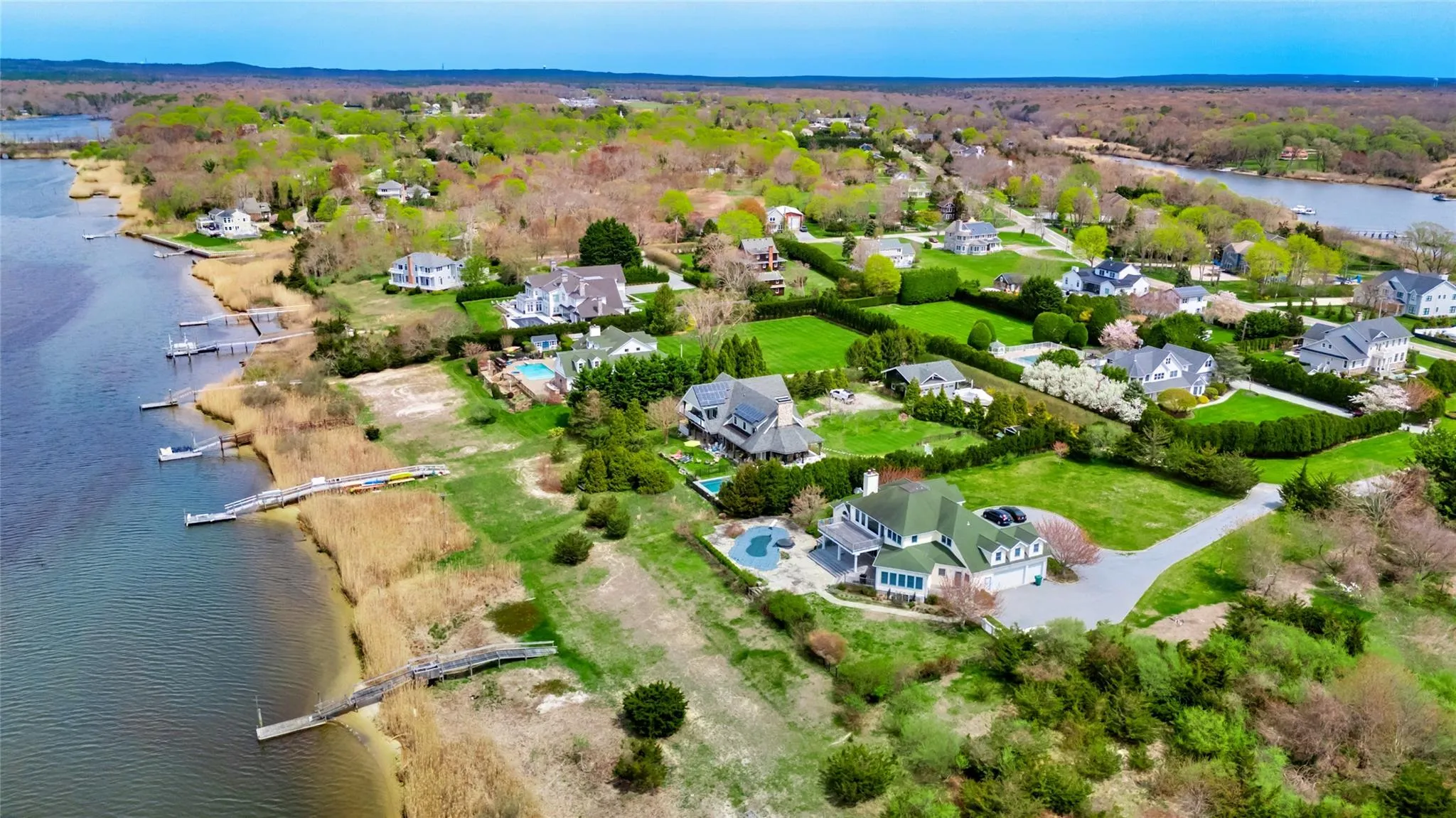 Birds eye view of property featuring a water view and a residential view Birds eye view of property featuring a water view and a residential view