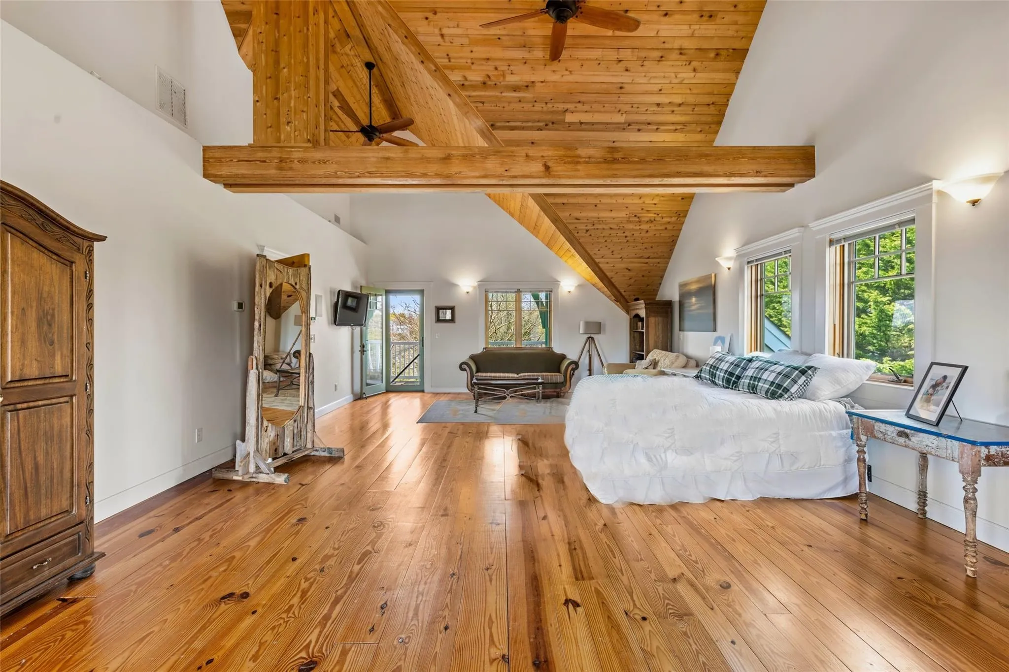 Living area featuring visible vents, ceiling fan, high vaulted ceiling, and light wood-type flooring Living area featuring visible vents, ceiling fan, high vaulted ceiling, and light wood-type flooring
