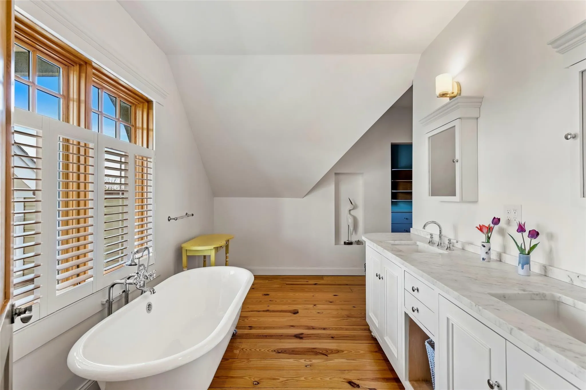Full bathroom with a sink, a freestanding tub, wood finished floors, and lofted ceiling Full bathroom with a sink, a freestanding tub, wood finished floors, and lofted ceiling