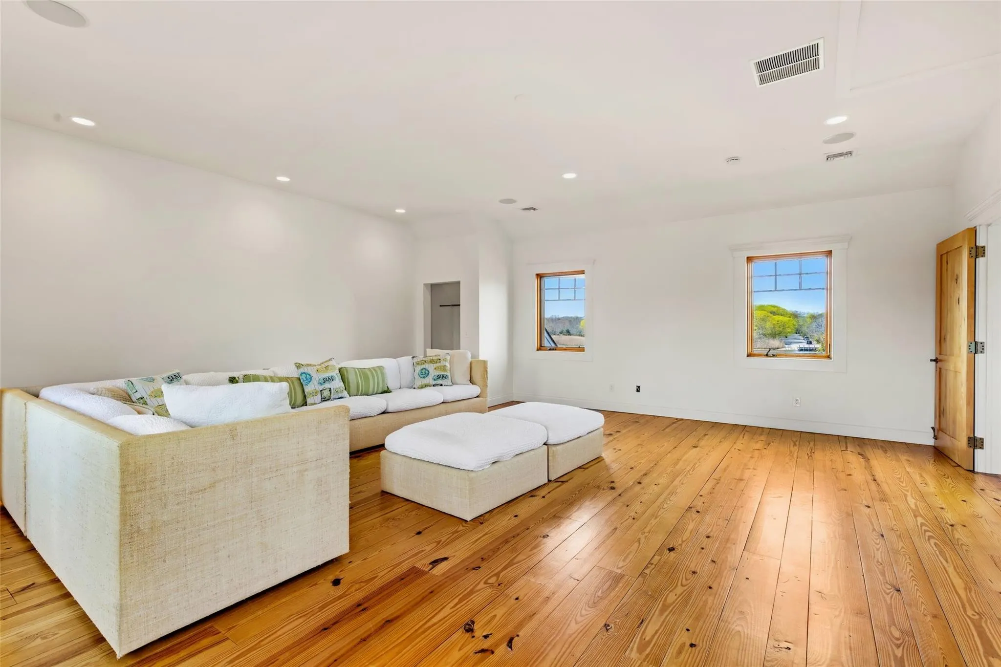 Living area featuring recessed lighting, baseboards, visible vents, and light wood-style floors Living area featuring recessed lighting, baseboards, visible vents, and light wood-style floors