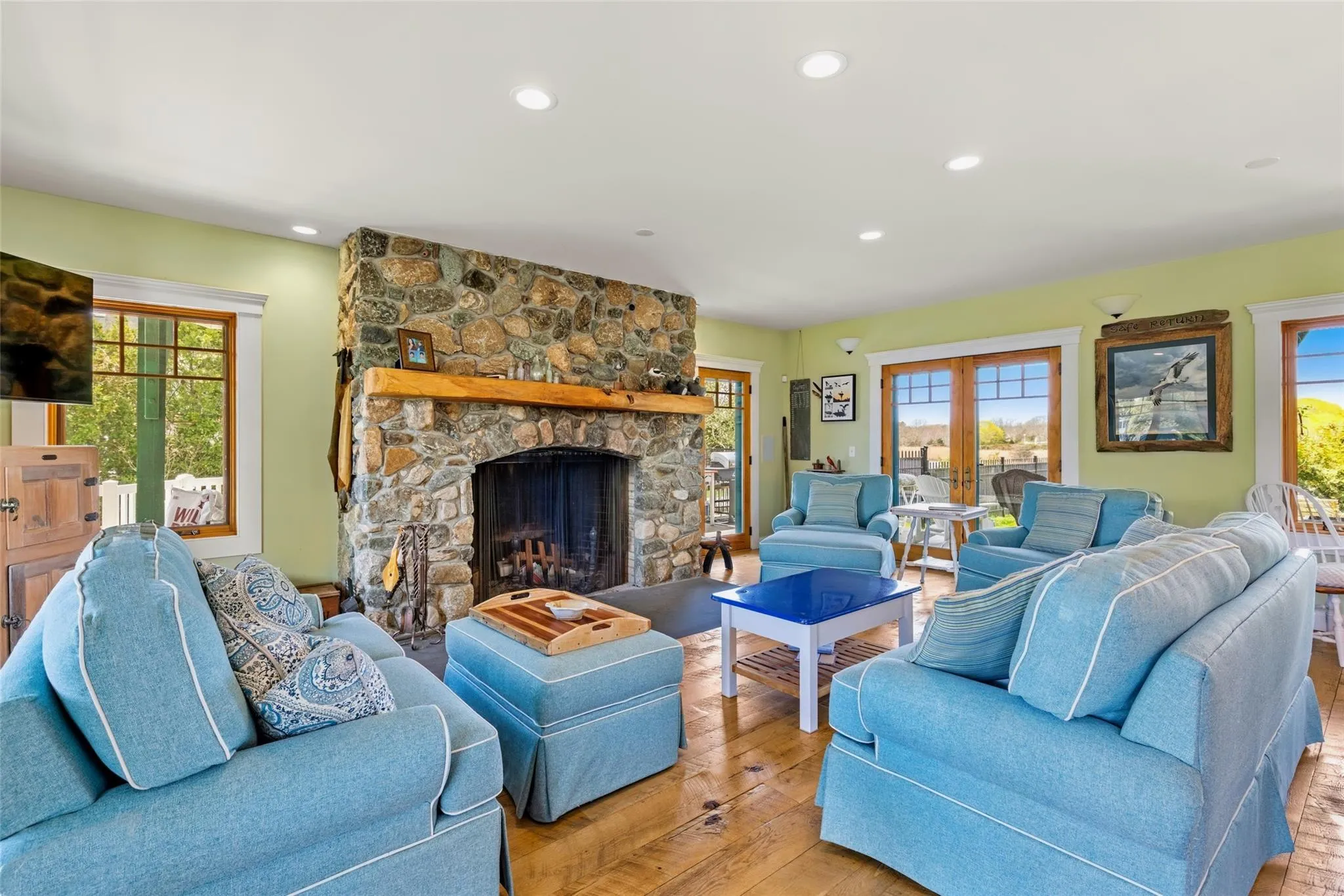 Living area featuring a fireplace, recessed lighting, french doors, and light wood-type flooring Living area featuring a fireplace, recessed lighting, french doors, and light wood-type flooring
