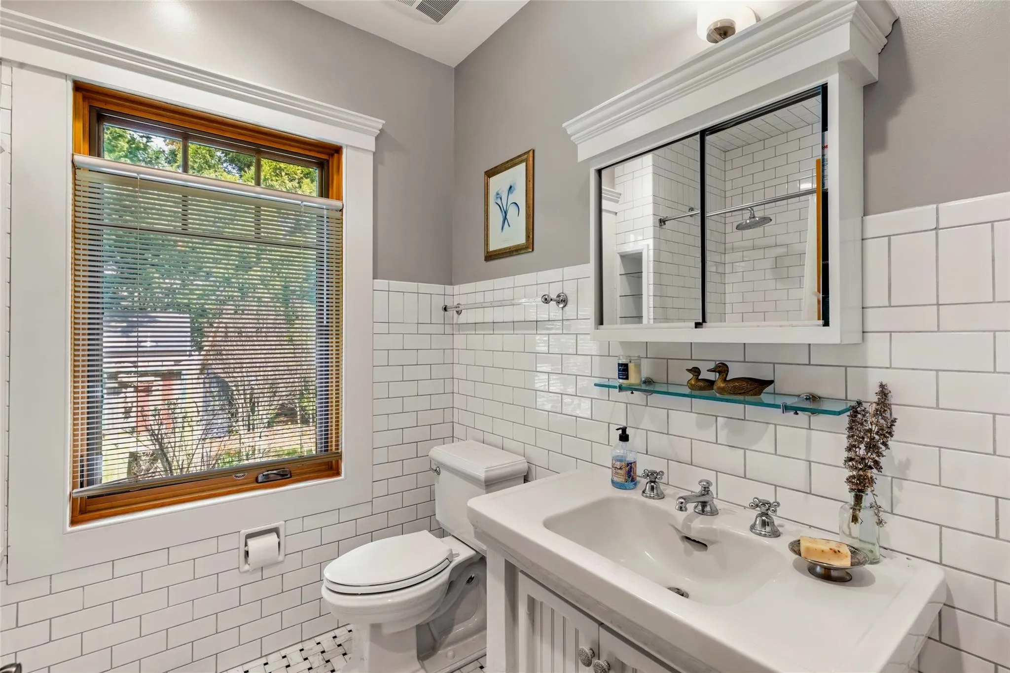Bathroom featuring a sink, a wainscoted wall, toilet, and tile walls Bathroom featuring a sink, a wainscoted wall, toilet, and tile walls