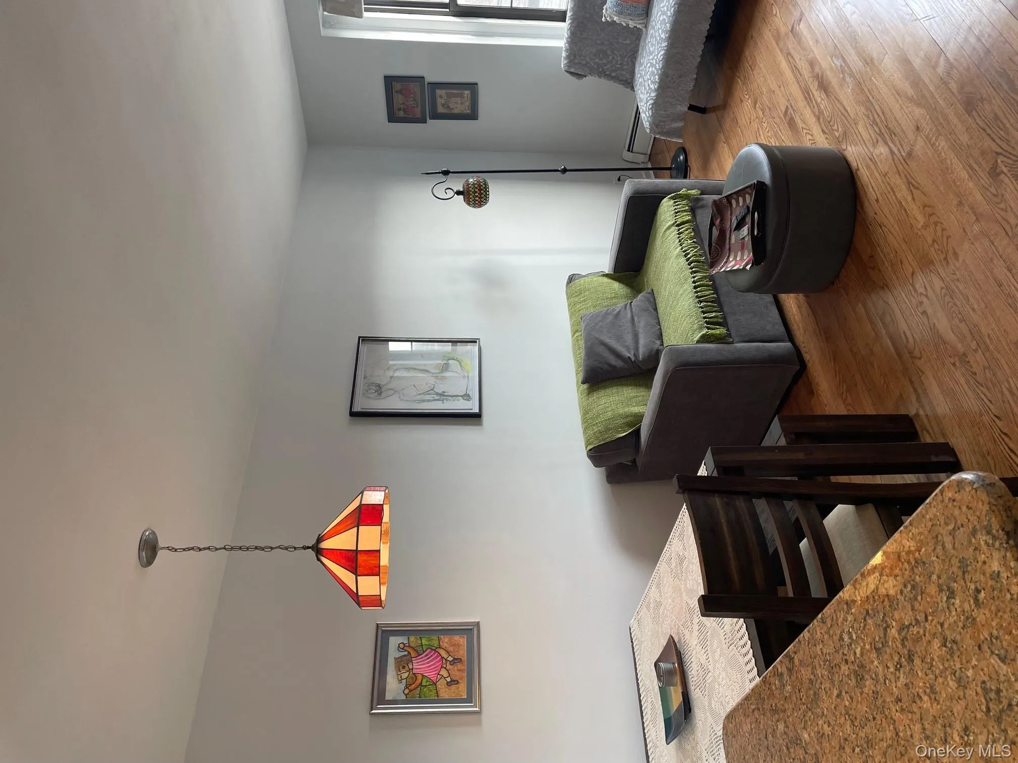 Living area with wood finished floors and baseboard heating Living area with wood finished floors and baseboard heating