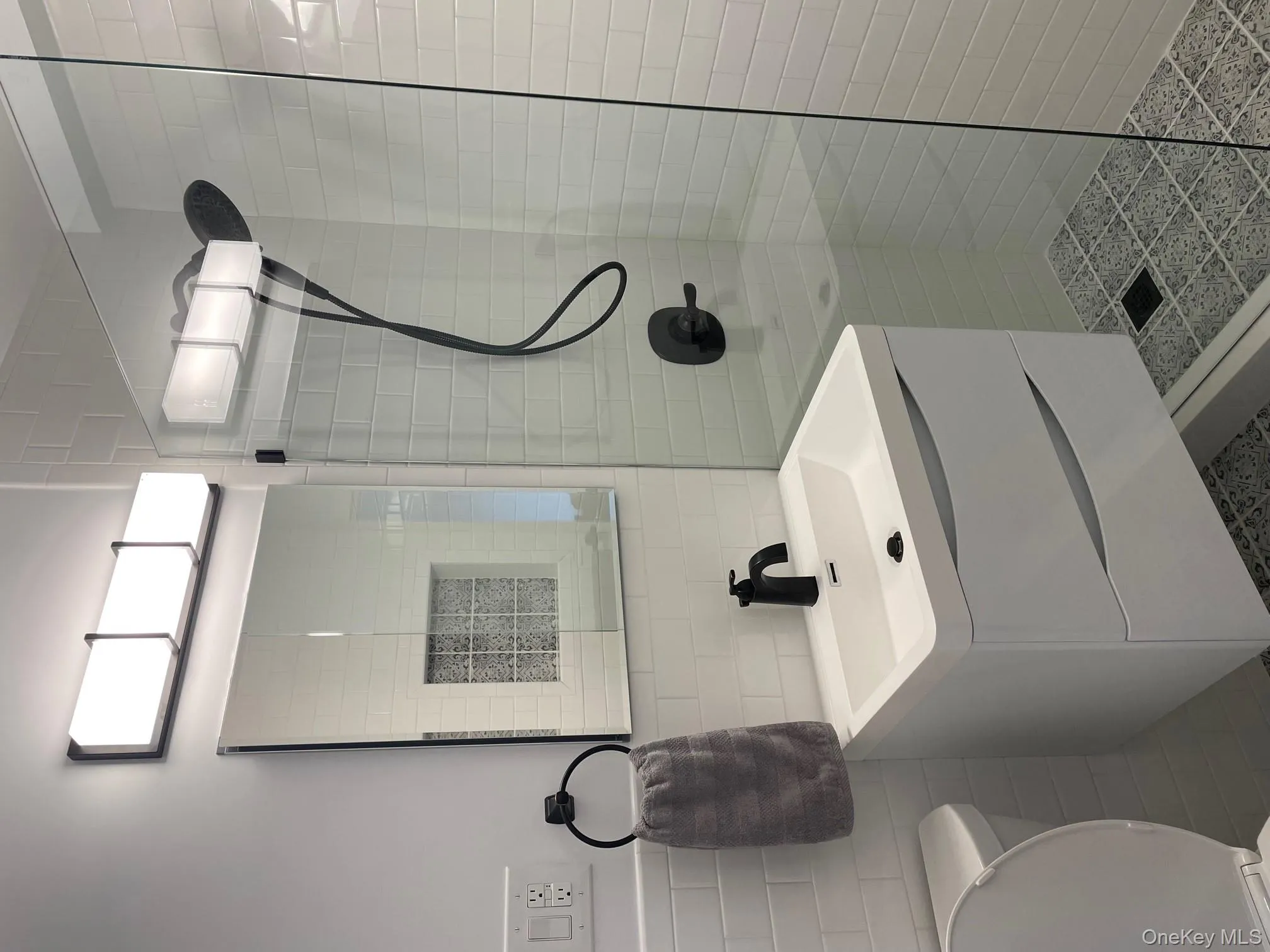 Full bathroom featuring vanity, wainscoting, toilet, tile walls, and tiled shower Full bathroom featuring vanity, wainscoting, toilet, tile walls, and tiled shower