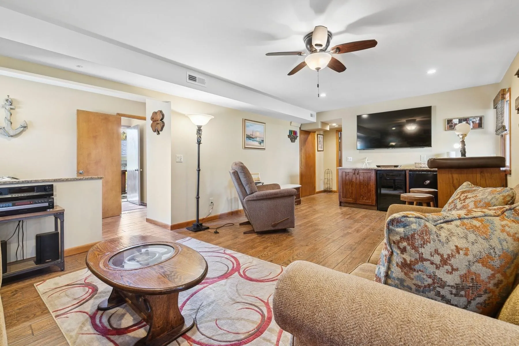 Living room featuring a ceiling fan, wet bar, visible vents, light wood-type flooring, and recessed lighting Living room featuring a ceiling fan, wet bar, visible vents, light wood-type flooring, and recessed lighting