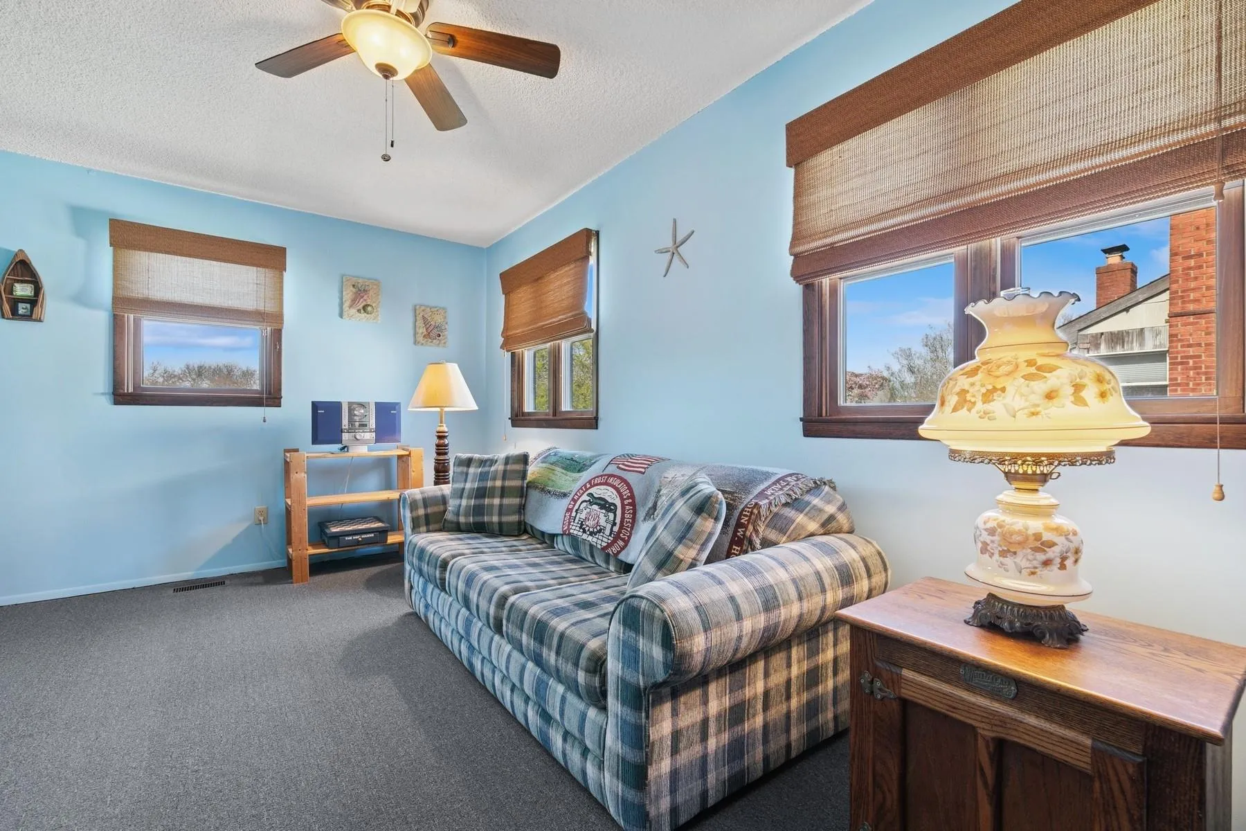 Carpeted living room with ceiling fan and a textured ceiling Carpeted living room with ceiling fan and a textured ceiling