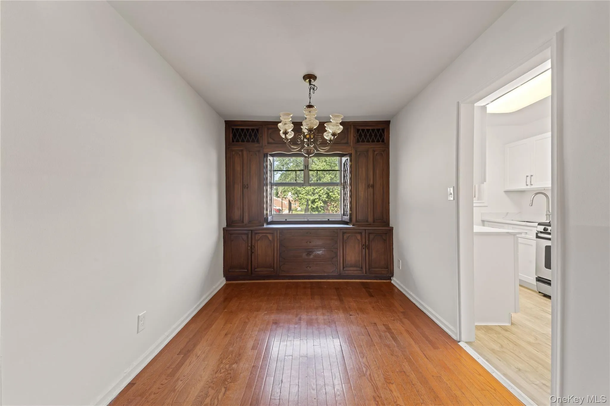 Unfurnished dining area featuring a chandelier and light wood-type flooring Unfurnished dining area featuring a chandelier and light wood-type flooring