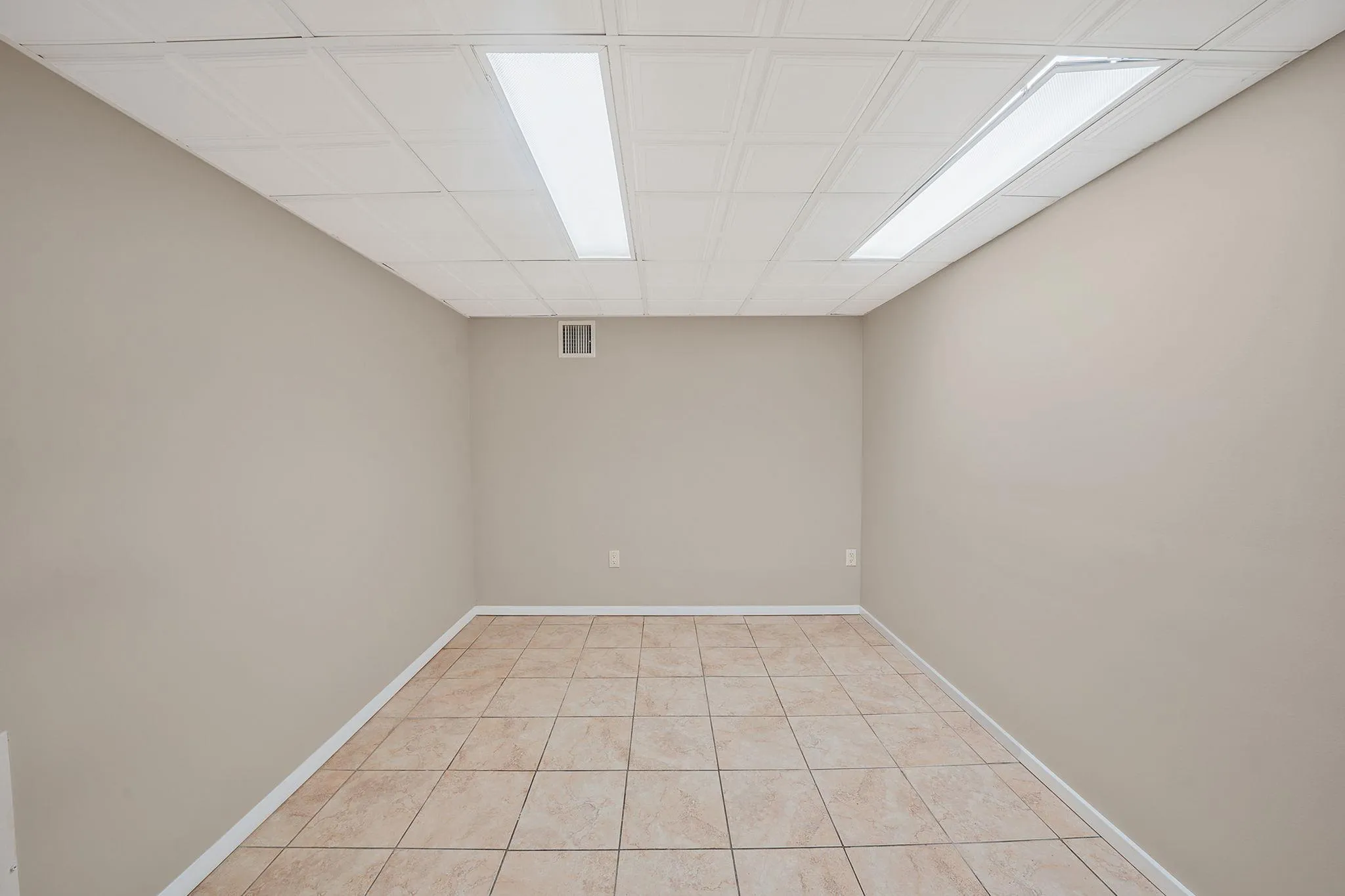 Empty room featuring visible vents, baseboards, and light tile patterned floors Empty room featuring visible vents, baseboards, and light tile patterned floors