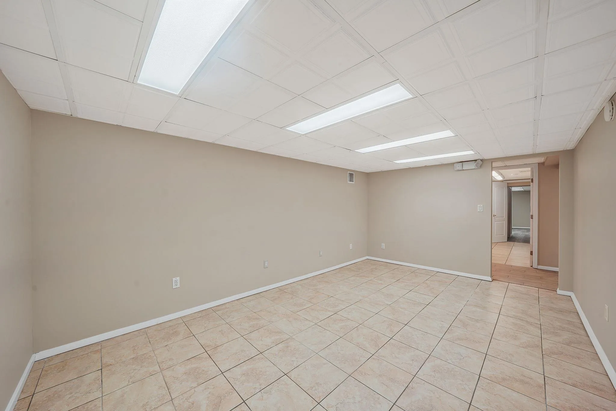 Empty room featuring baseboards, visible vents, and light tile patterned floors Empty room featuring baseboards, visible vents, and light tile patterned floors