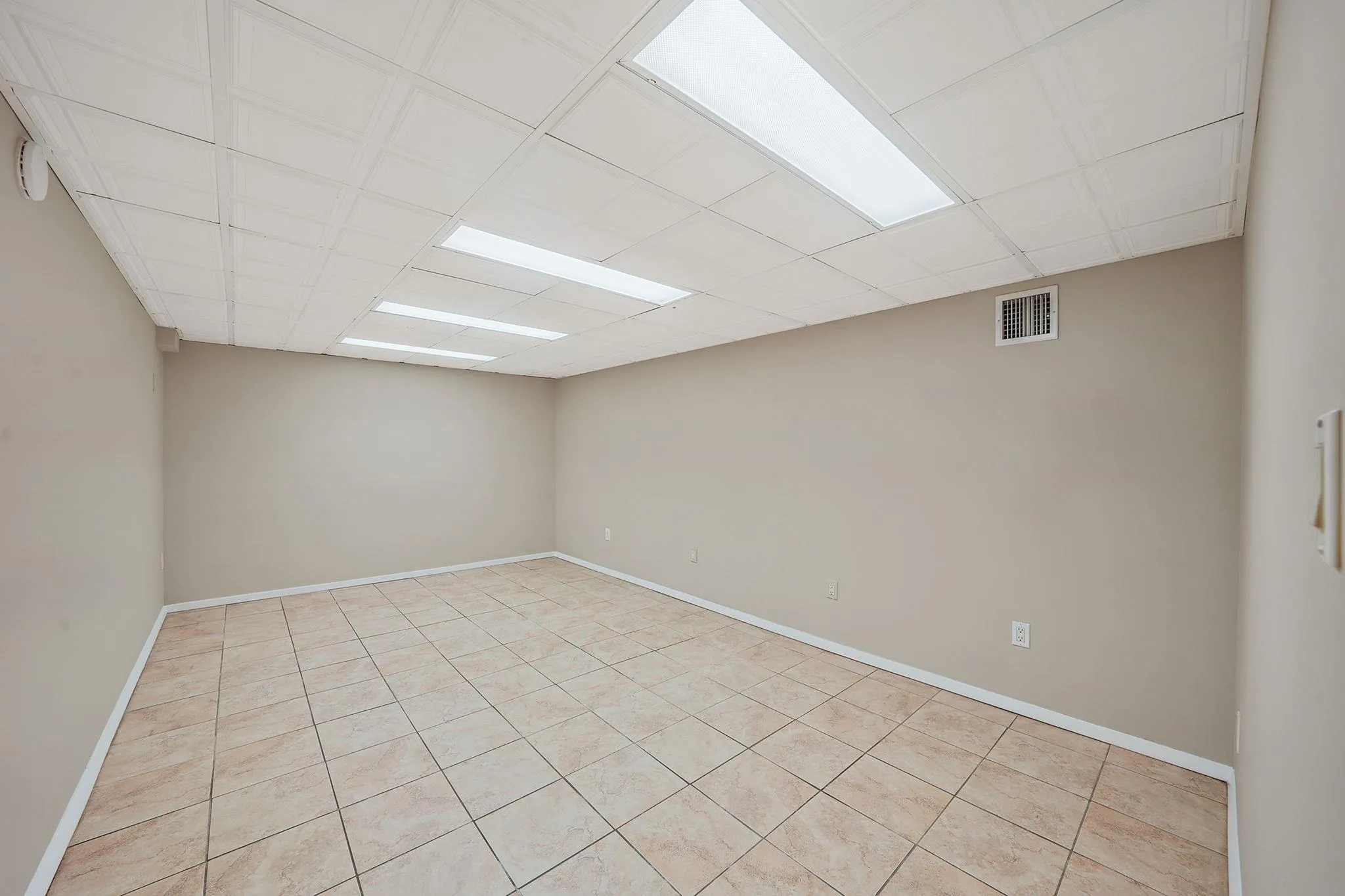 Unfurnished room featuring light tile patterned floors, baseboards, and visible vents Unfurnished room featuring light tile patterned floors, baseboards, and visible vents