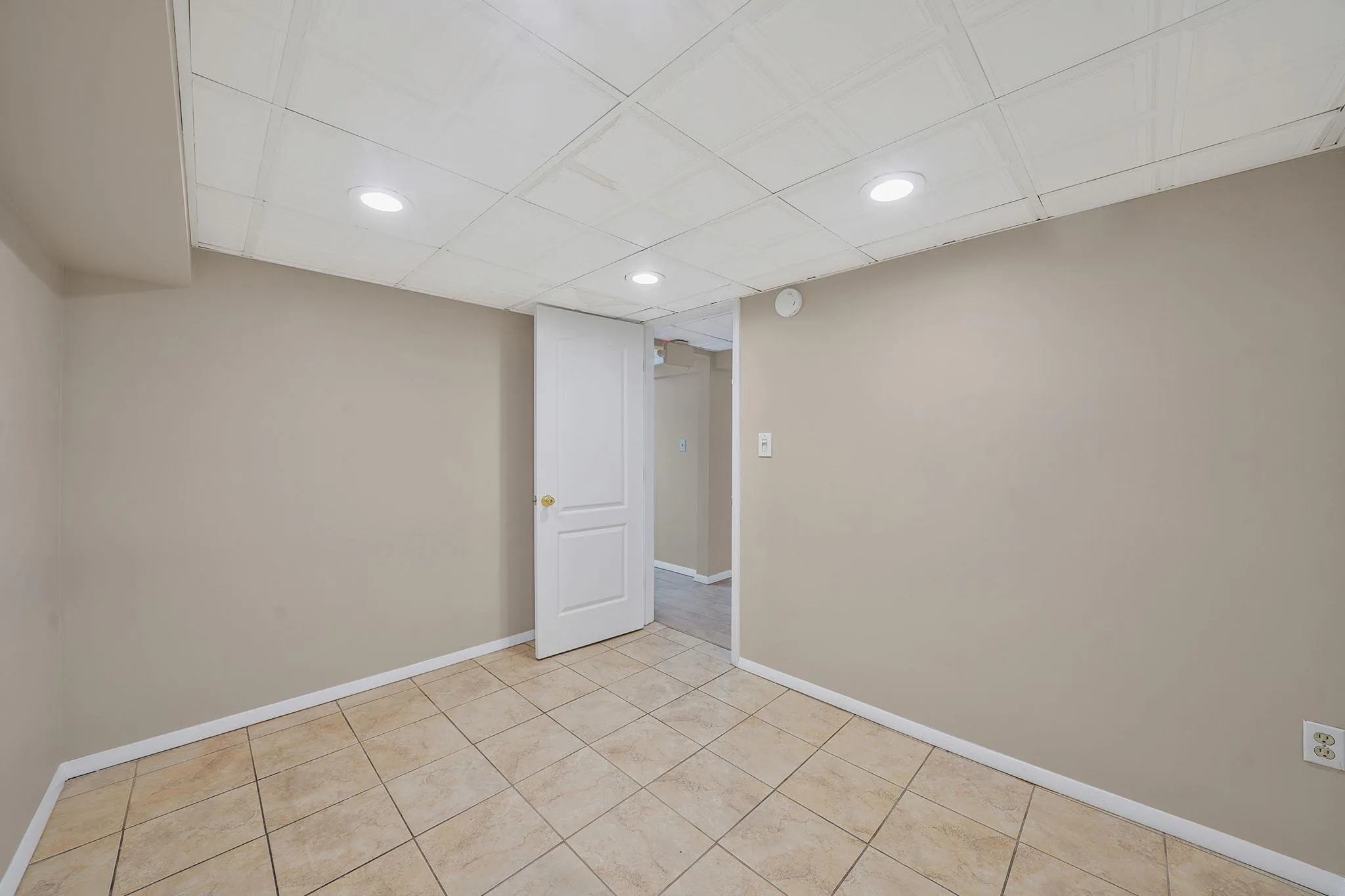 Finished below grade area with recessed lighting, baseboards, and light tile patterned flooring Finished below grade area with recessed lighting, baseboards, and light tile patterned flooring