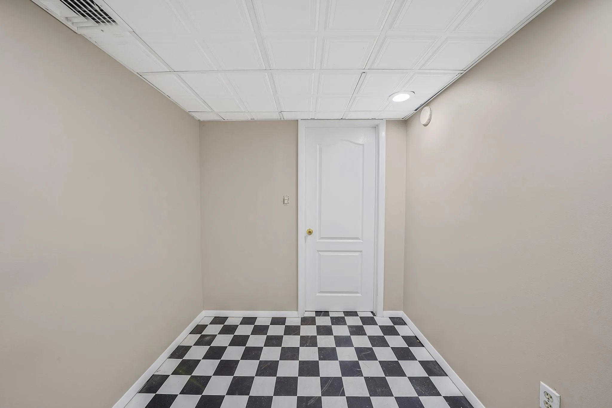 Finished basement with baseboards, visible vents, and tile patterned floors Finished basement with baseboards, visible vents, and tile patterned floors