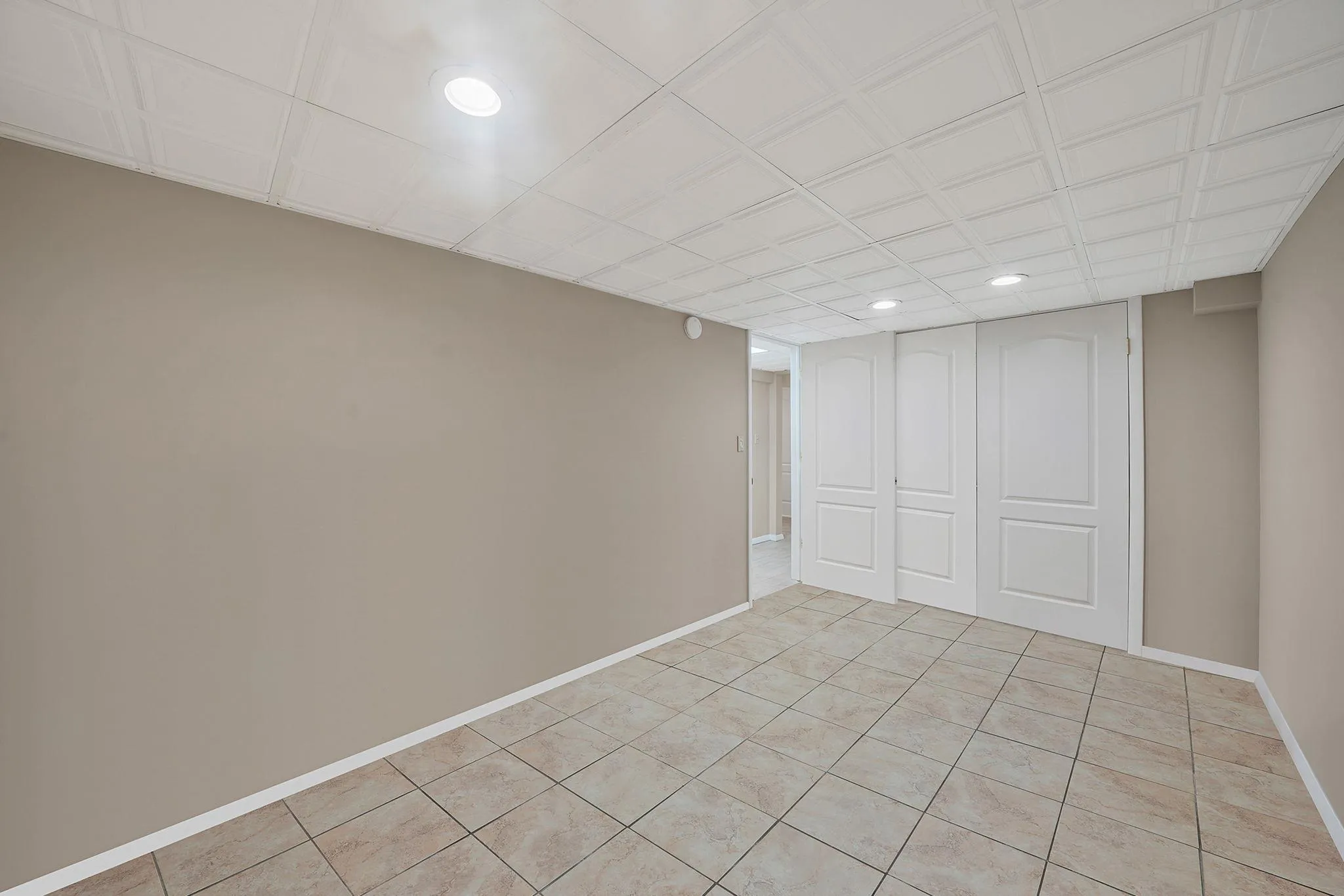 Finished below grade area featuring recessed lighting, baseboards, and light tile patterned flooring Finished below grade area featuring recessed lighting, baseboards, and light tile patterned flooring