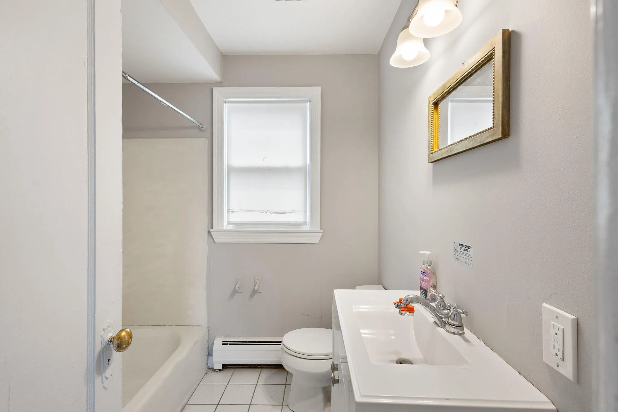 Full bath featuring tile patterned floors, a baseboard radiator, vanity, and toilet Full bath featuring tile patterned floors, a baseboard radiator, vanity, and toilet