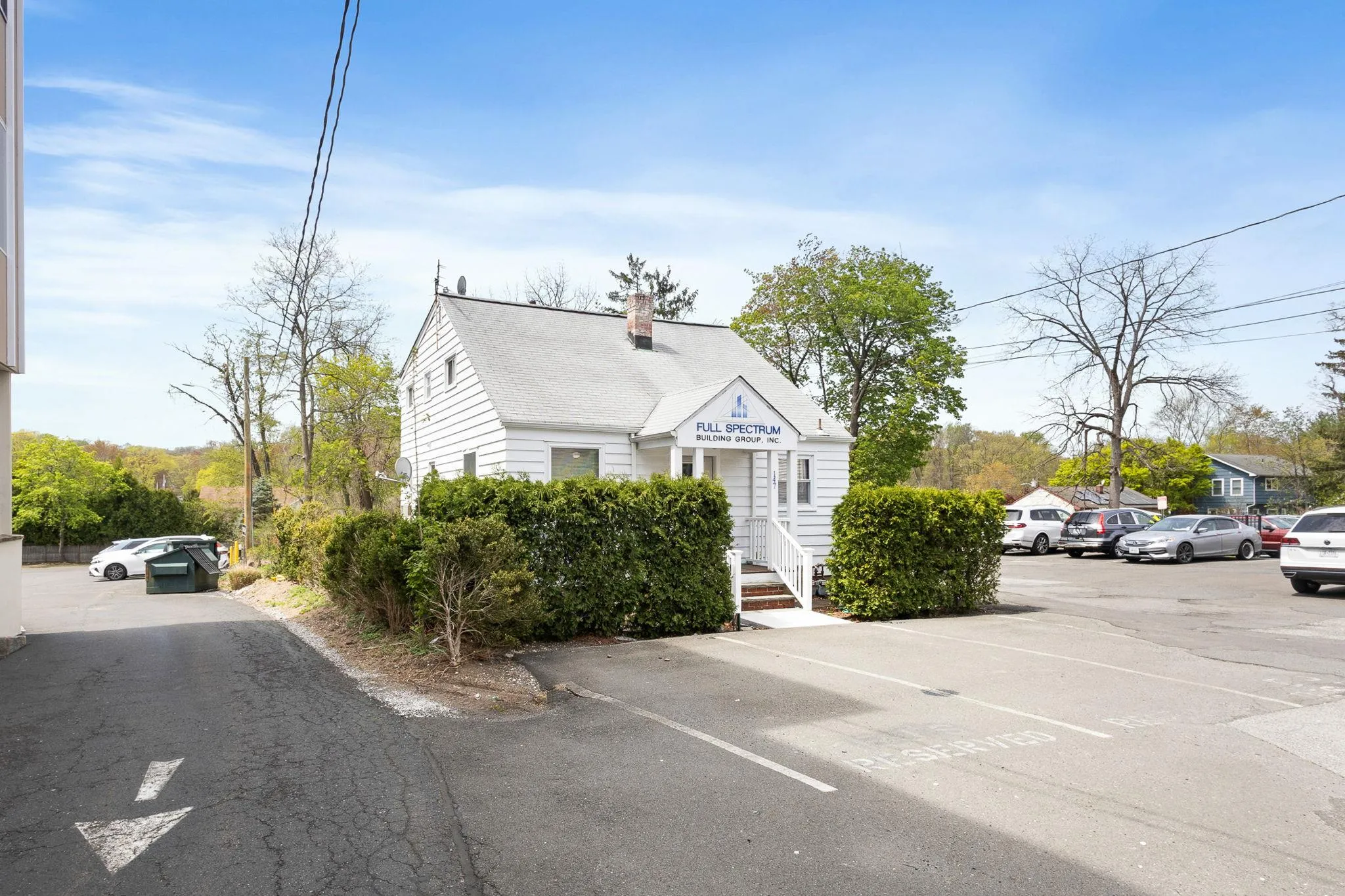 View of front of property with a chimney and uncovered parking View of front of property with a chimney and uncovered parking