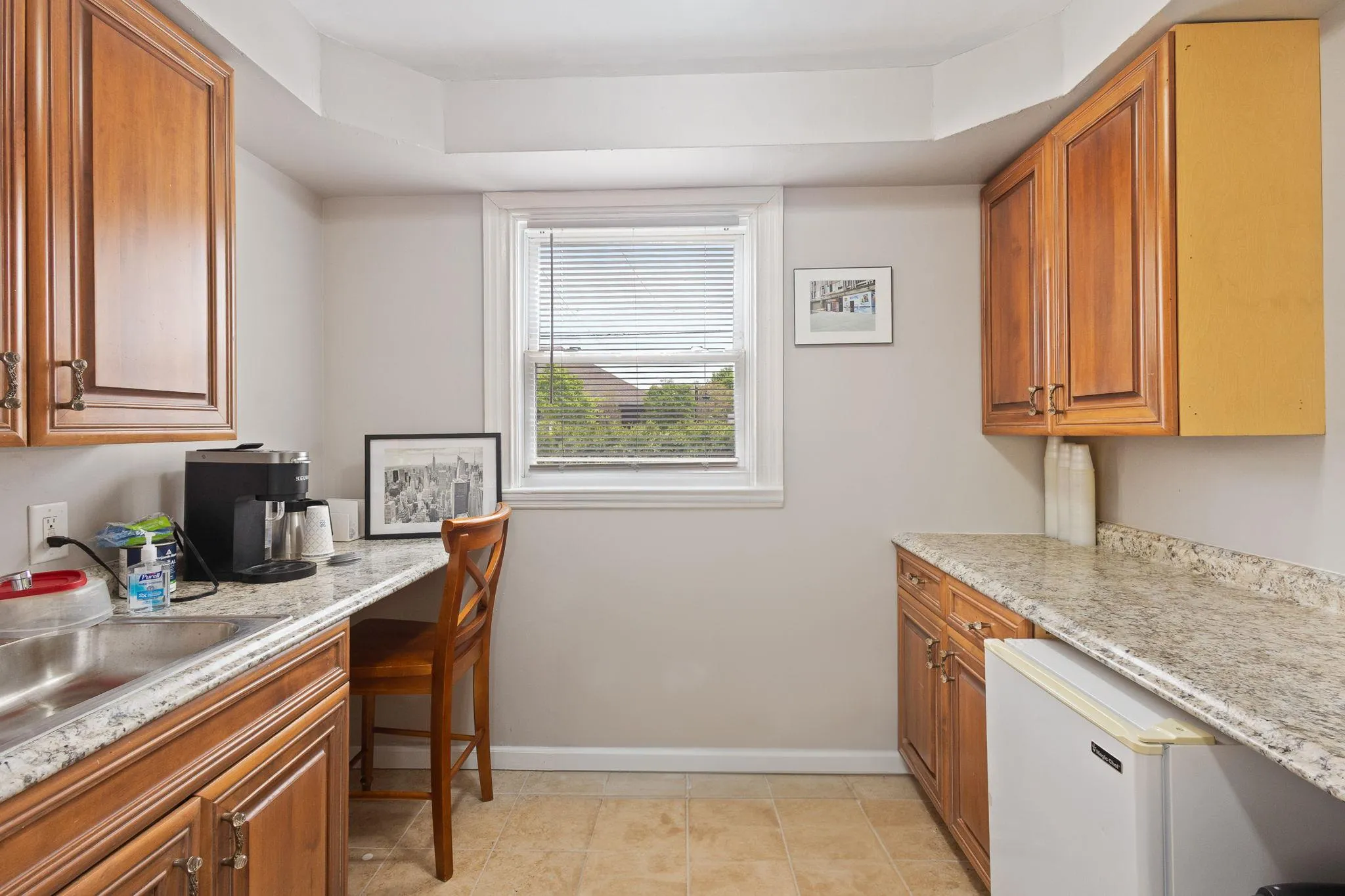 Kitchen featuring built in study area, baseboards, brown cabinetry, and a sink Kitchen featuring built in study area, baseboards, brown cabinetry, and a sink