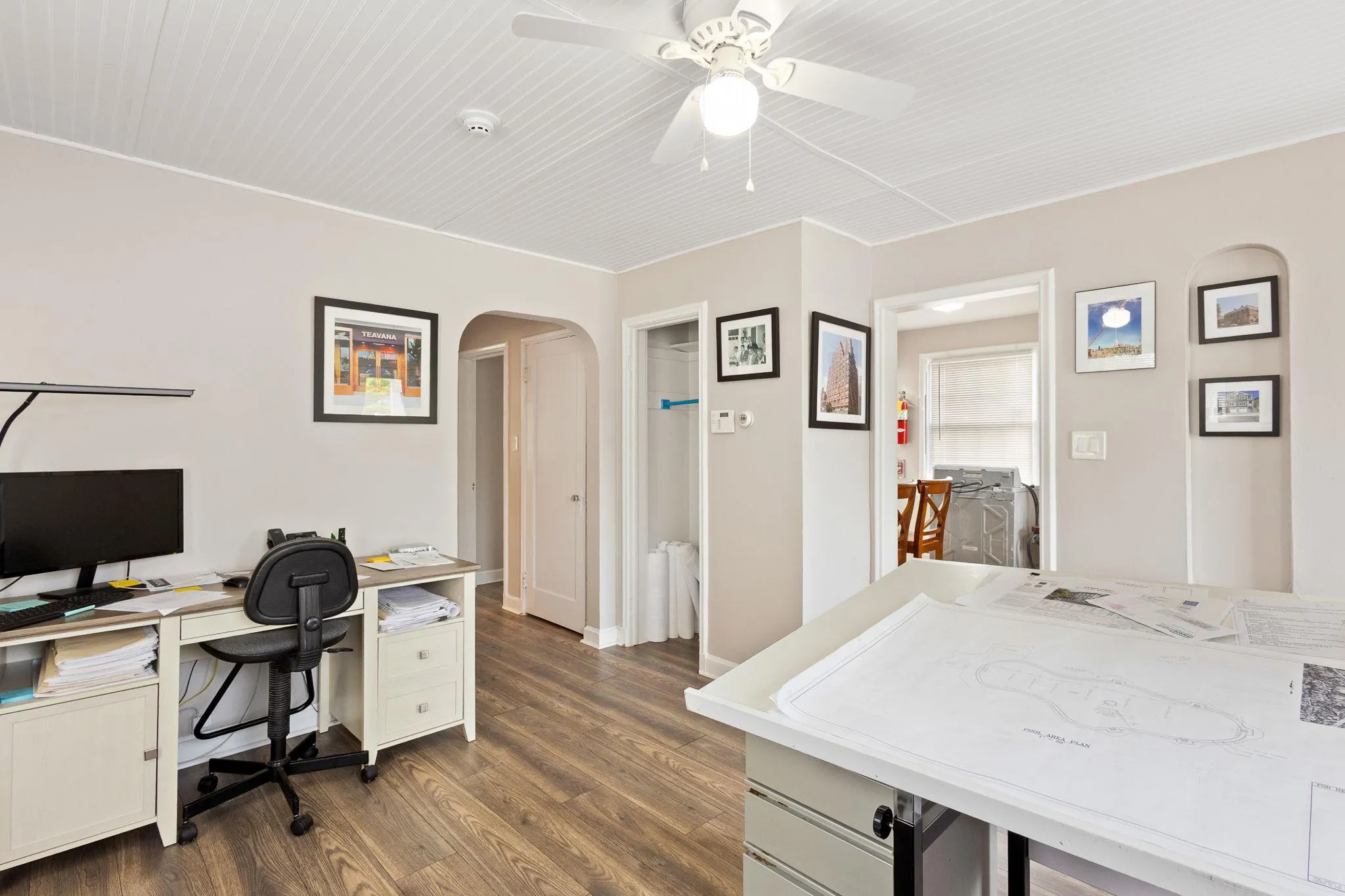 Office space featuring baseboards, arched walkways, dark wood finished floors, and ceiling fan Office space featuring baseboards, arched walkways, dark wood finished floors, and ceiling fan