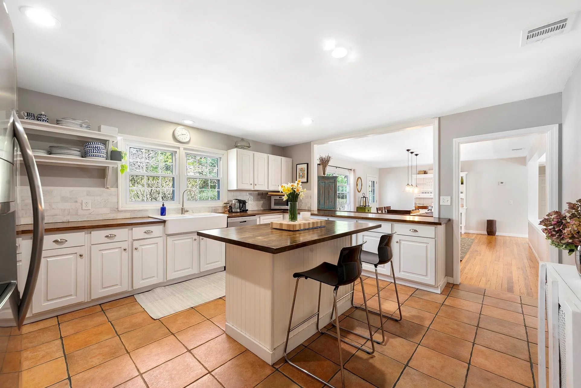 Kitchen featuring butcher block countertops, a sink, backsplash, a kitchen bar, and recessed lighting Kitchen featuring butcher block countertops, a sink, backsplash, a kitchen bar, and recessed lighting