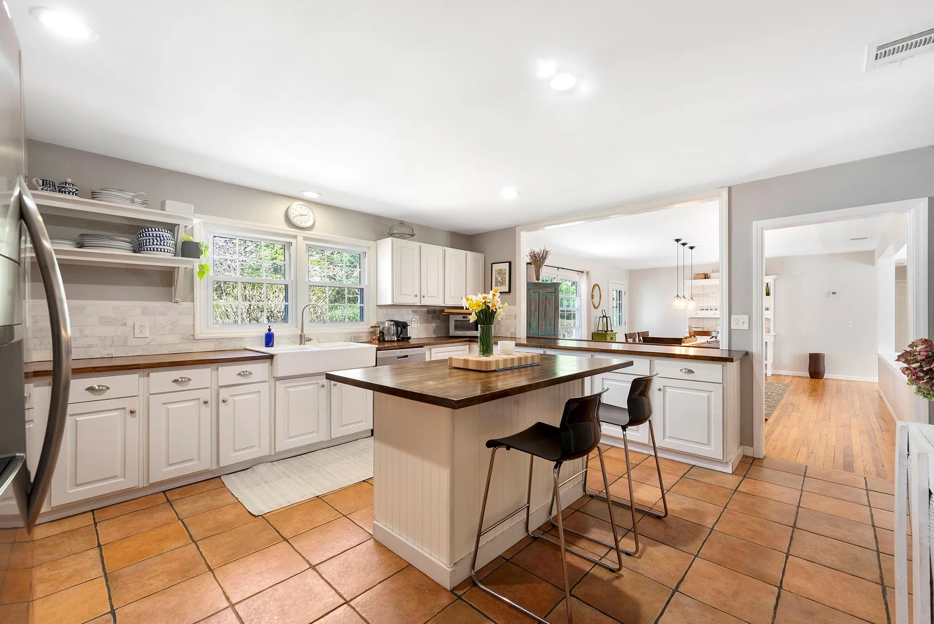 Kitchen with wooden counters, a sink, tasteful backsplash, a kitchen bar, and light tile patterned floors Kitchen with wooden counters, a sink, tasteful backsplash, a kitchen bar, and light tile patterned floors