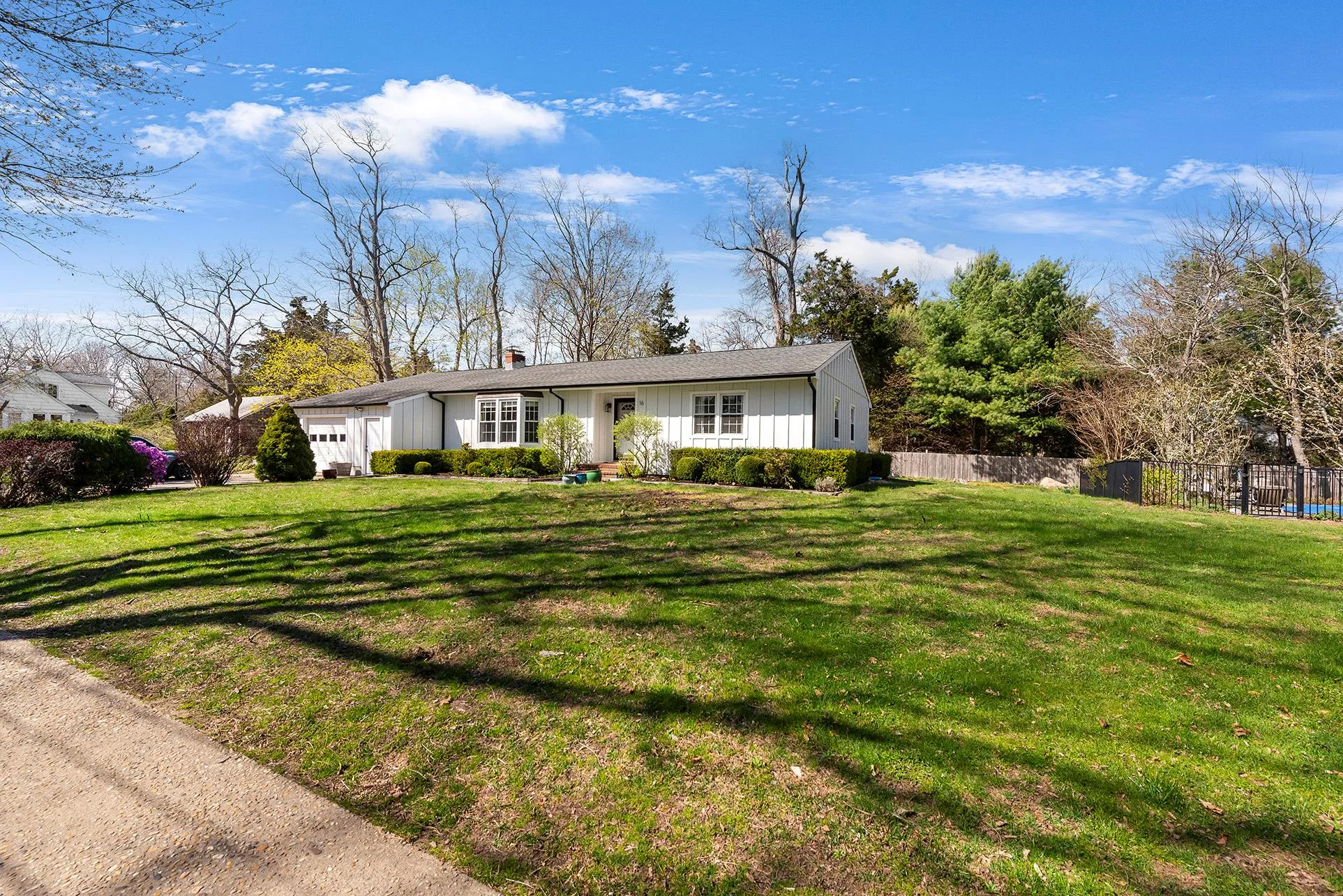 Single story home with board and batten siding, a garage, and a chimney Single story home with board and batten siding, a garage, and a chimney