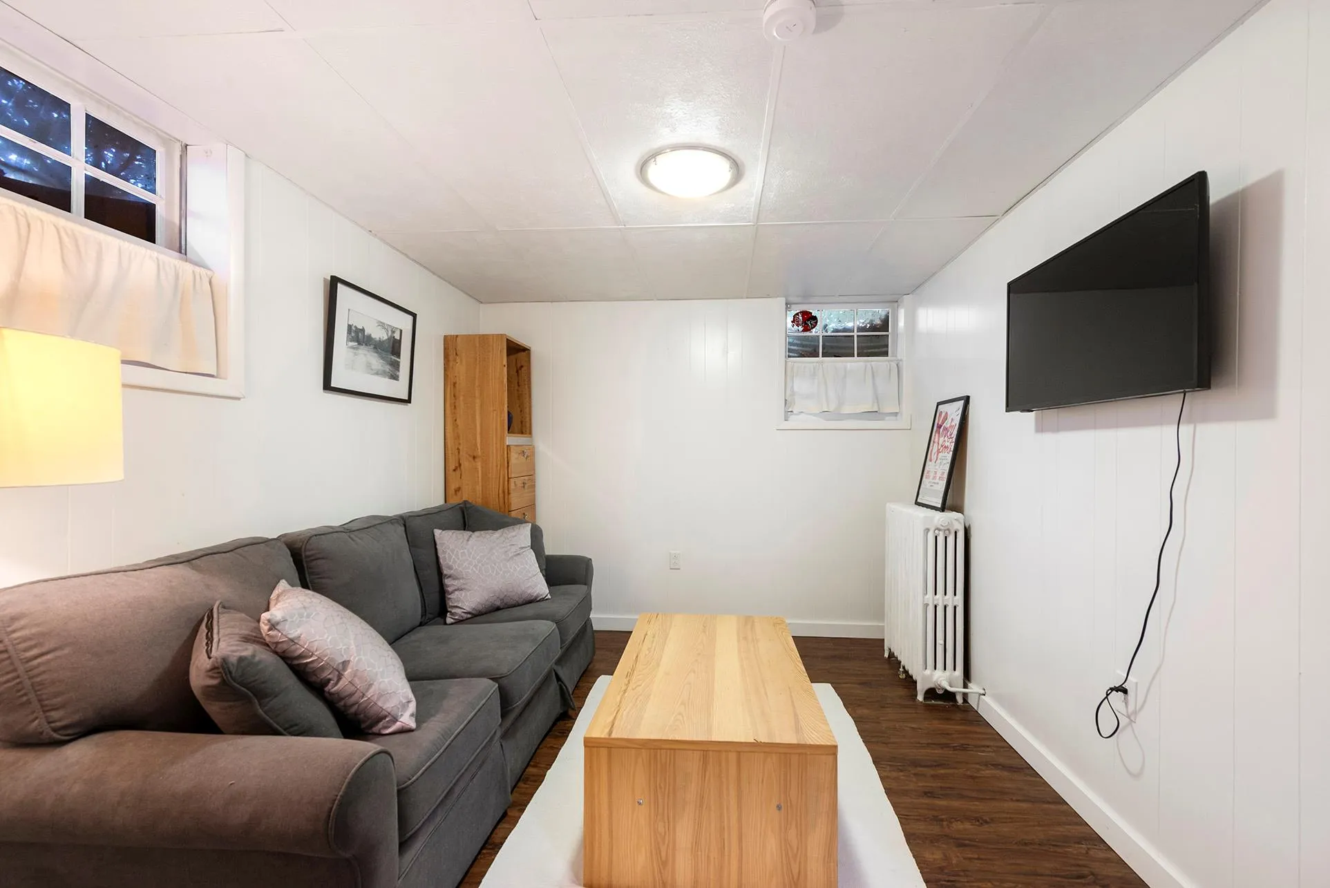 Living room featuring radiator, dark wood-style flooring, and baseboards Living room featuring radiator, dark wood-style flooring, and baseboards