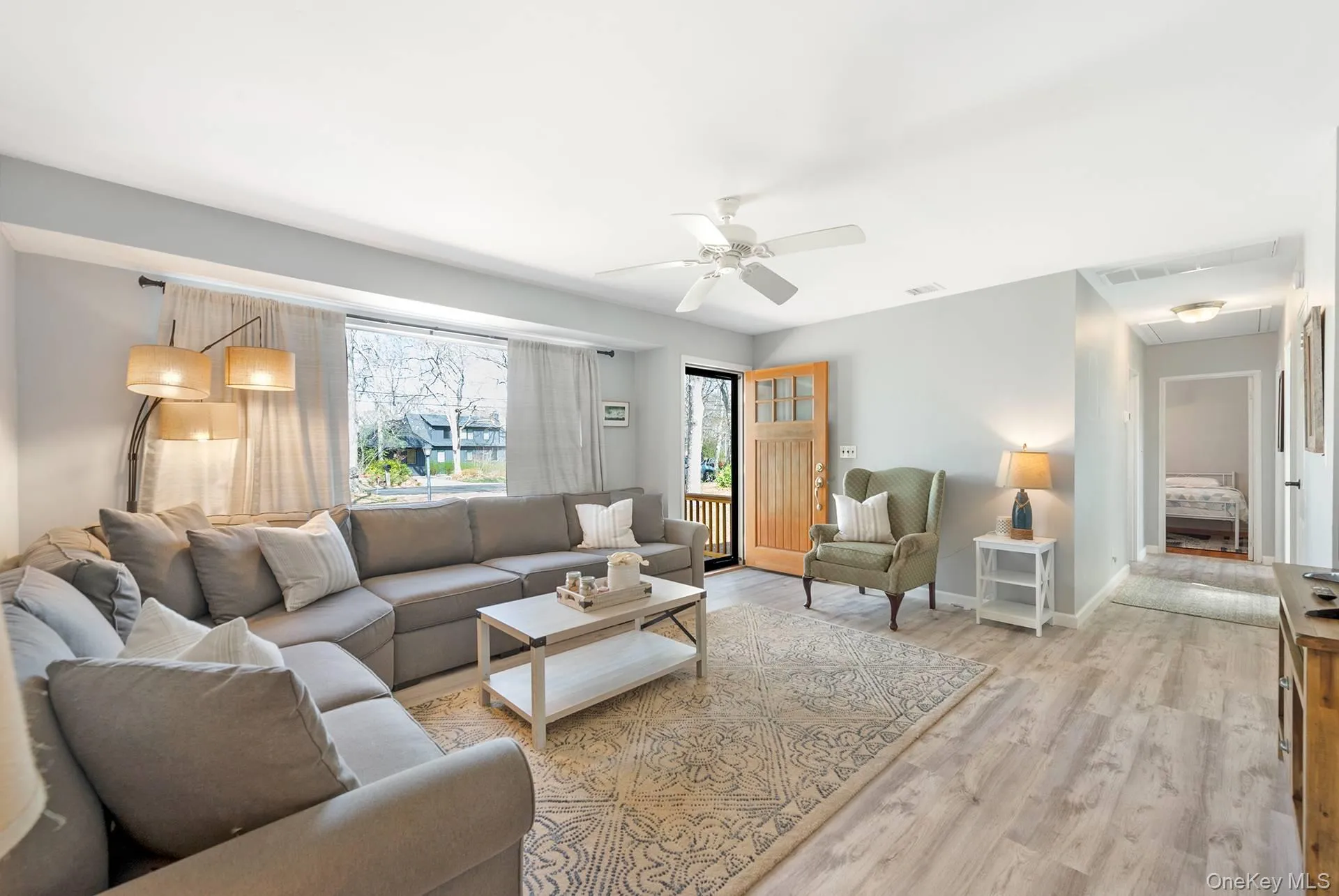 Living area featuring light wood-style floors, baseboards, a ceiling fan, and visible vents Living area featuring light wood-style floors, baseboards, a ceiling fan, and visible vents