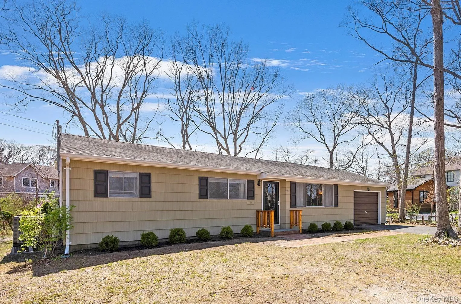 Ranch-style home with an attached garage, driveway, and a front yard Ranch-style home with an attached garage, driveway, and a front yard