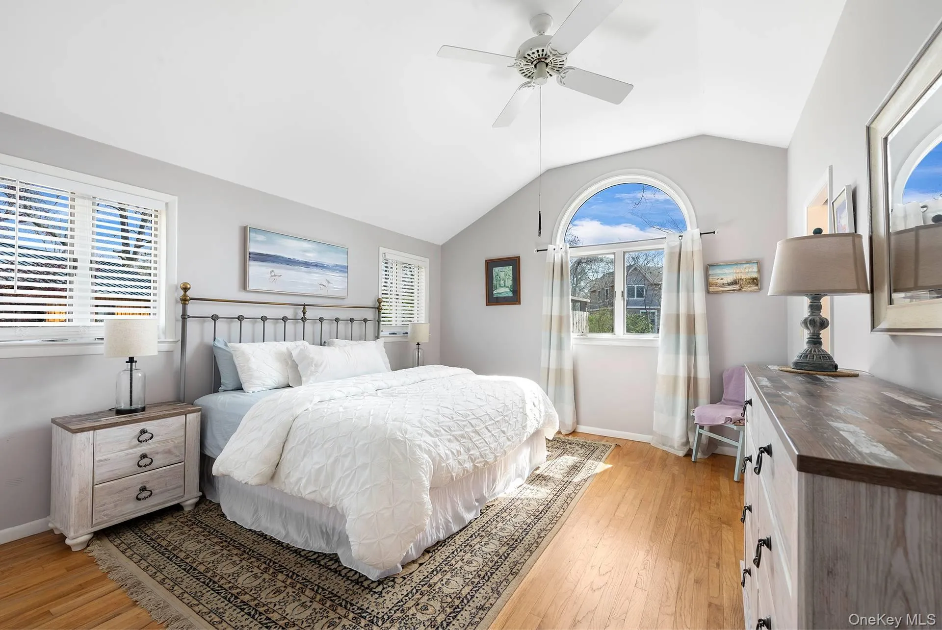 Bedroom featuring baseboards, vaulted ceiling, ceiling fan, and light wood-type flooring Bedroom featuring baseboards, vaulted ceiling, ceiling fan, and light wood-type flooring