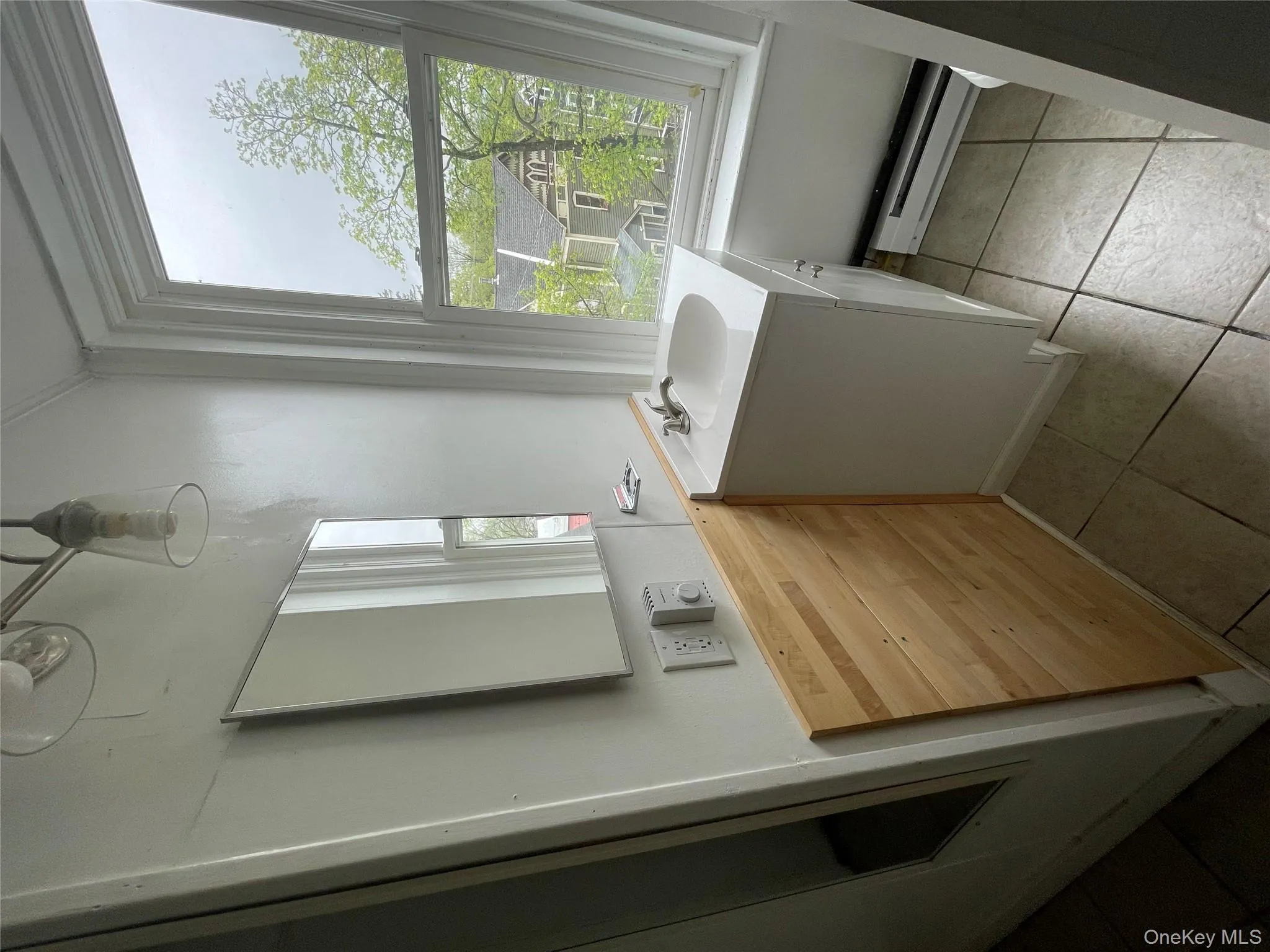 Bathroom with vanity, a baseboard radiator, and tile patterned floors Bathroom with vanity, a baseboard radiator, and tile patterned floors