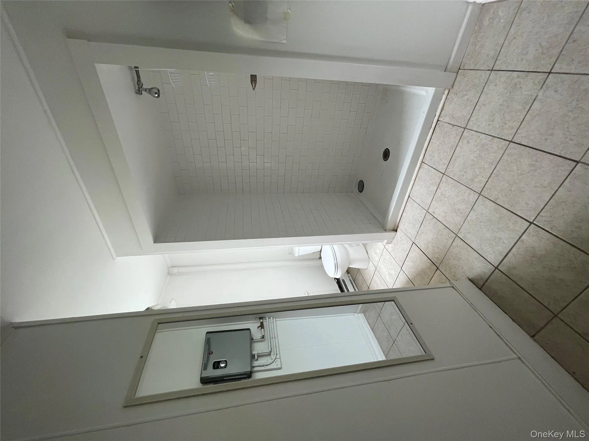 Bathroom featuring tile patterned flooring, toilet, and a shower stall Bathroom featuring tile patterned flooring, toilet, and a shower stall