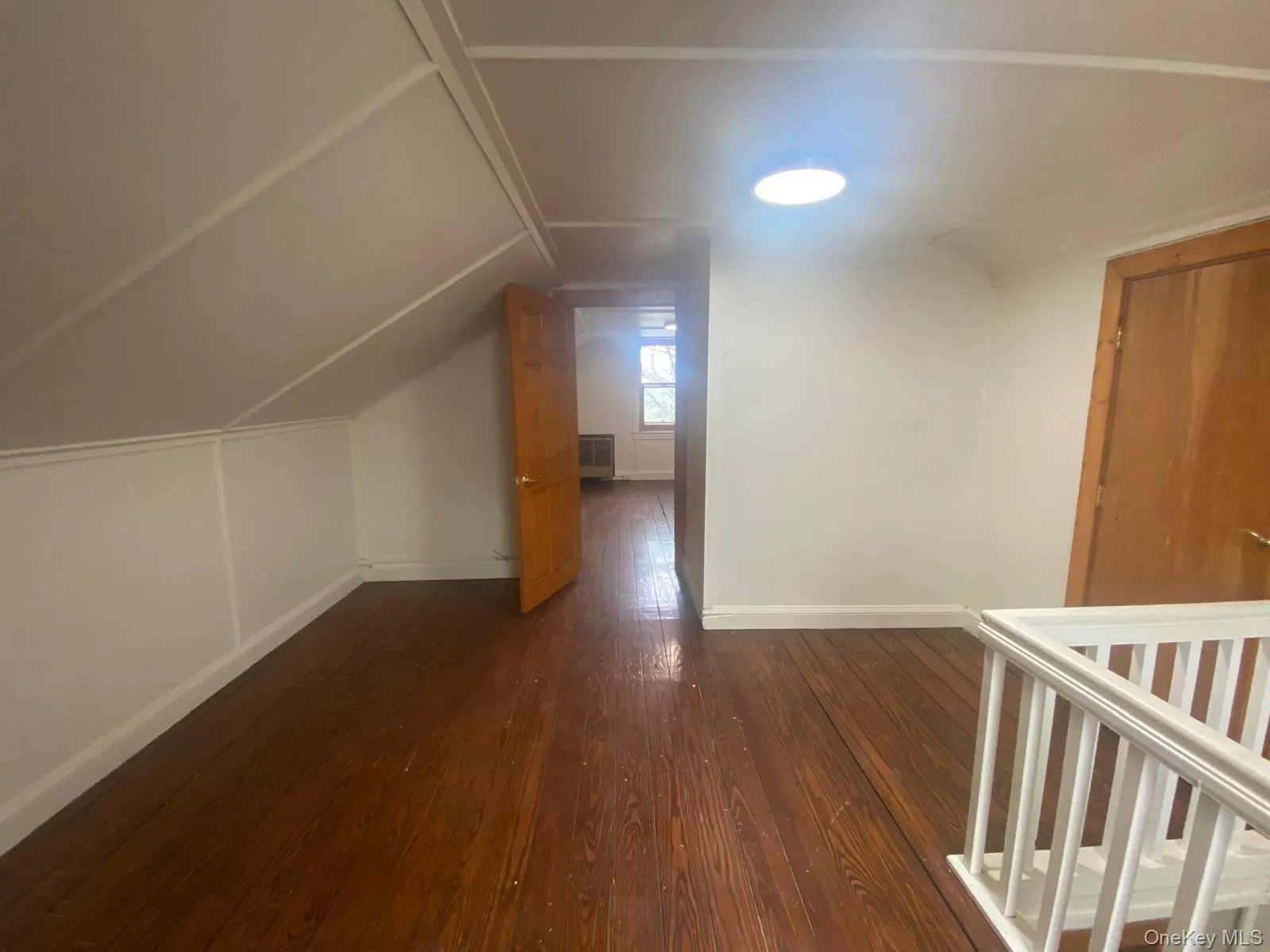 Bonus room with baseboards, dark wood-style floors, and lofted ceiling Bonus room with baseboards, dark wood-style floors, and lofted ceiling