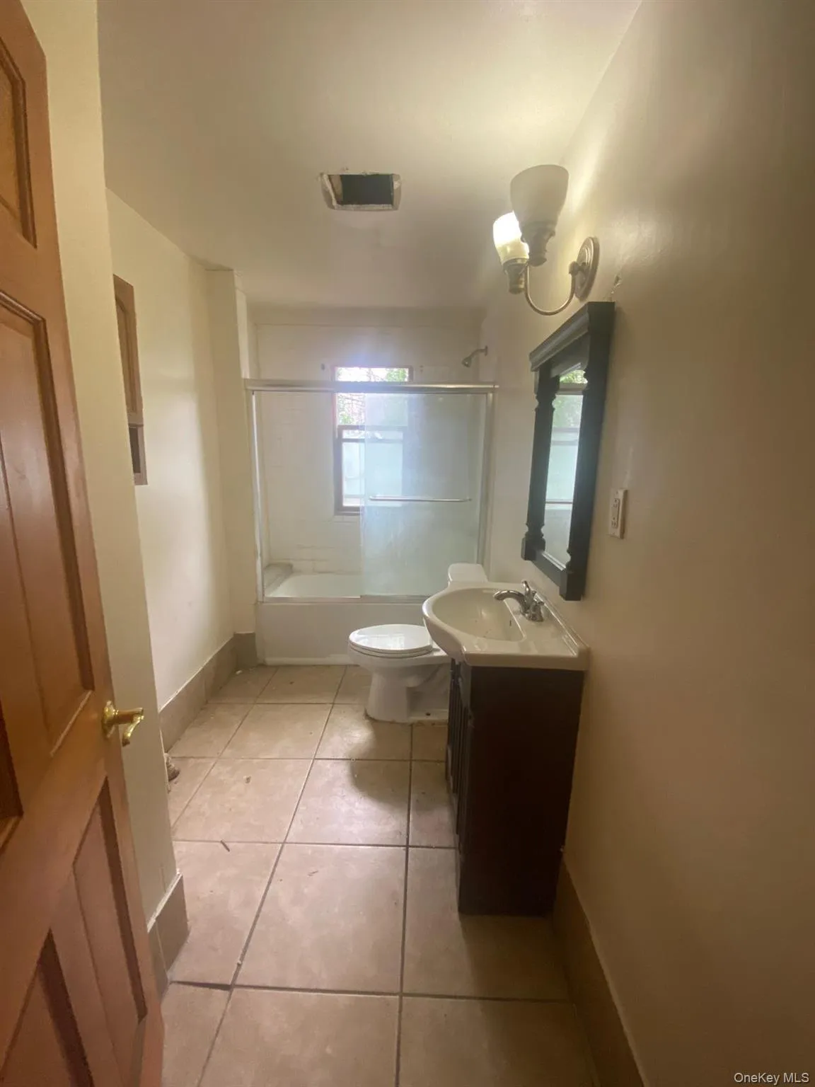 Bathroom with vanity, toilet, baseboards, washtub / shower combination, and tile patterned floors Bathroom with vanity, toilet, baseboards, washtub / shower combination, and tile patterned floors