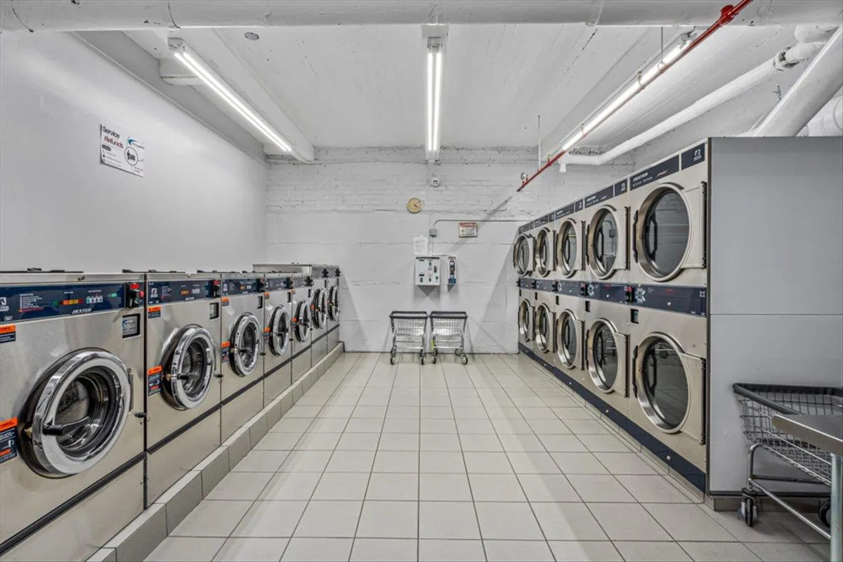 Laundry room with washer and dryer and light tile patterned flooring Laundry room with washer and dryer and light tile patterned flooring