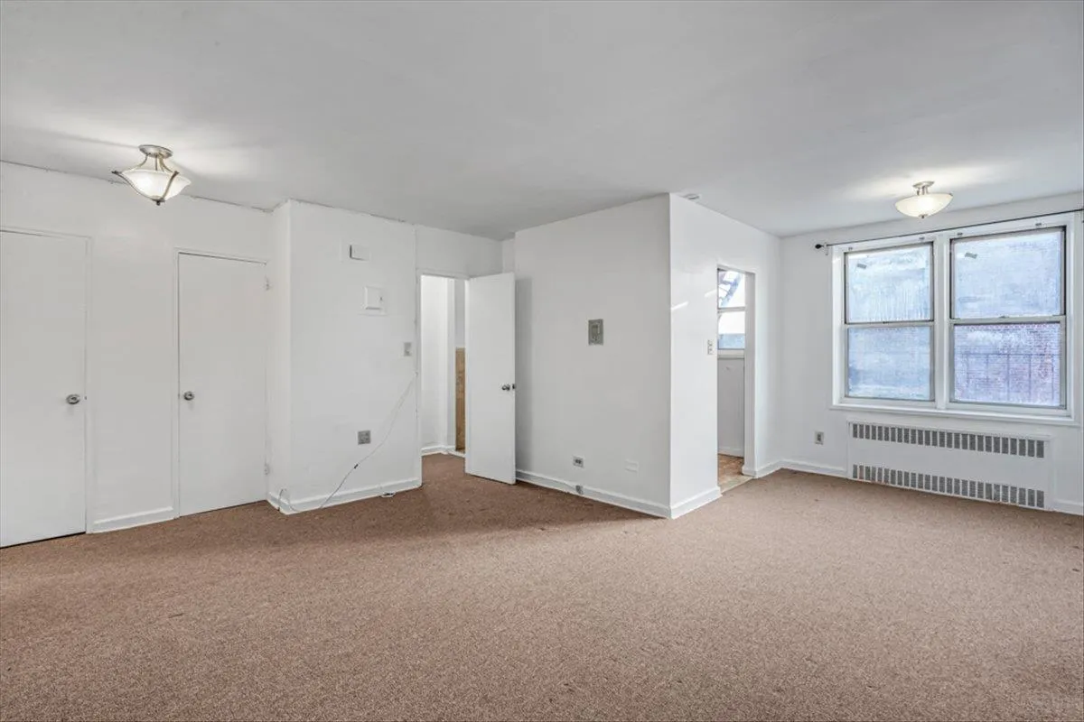 Carpeted empty room with radiator Carpeted empty room with radiator