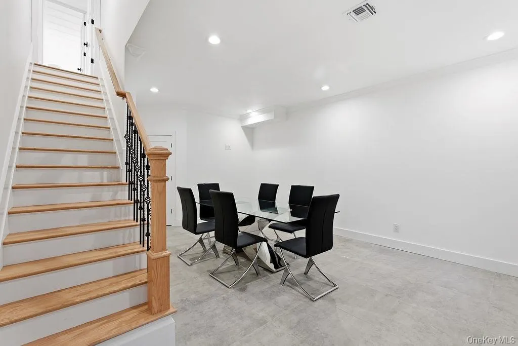 Dining room featuring stairs, crown molding, concrete flooring, and recessed lighting Dining room featuring stairs, crown molding, concrete flooring, and recessed lighting
