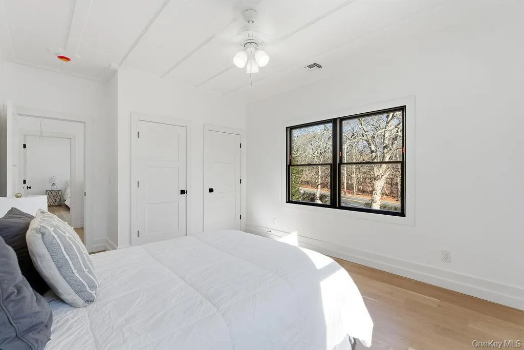 Bedroom featuring light wood-type flooring, attic access, and ceiling fan Bedroom featuring light wood-type flooring, attic access, and ceiling fan