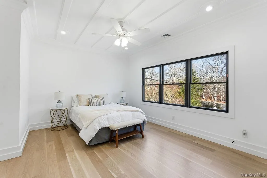 Bedroom featuring light wood-style flooring, a ceiling fan, ornamental molding, beamed ceiling, and recessed lighting Bedroom featuring light wood-style flooring, a ceiling fan, ornamental molding, beamed ceiling, and recessed lighting