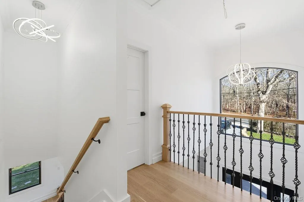Stairs featuring a chandelier and wood finished floors Stairs featuring a chandelier and wood finished floors