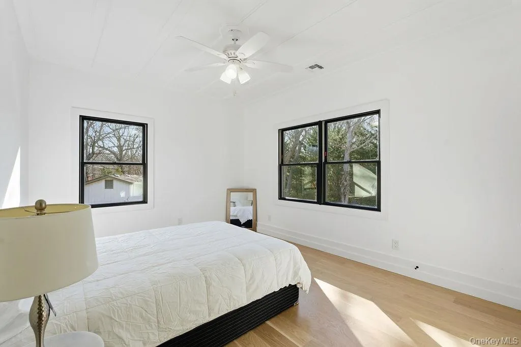 Bedroom with light wood-style flooring and a ceiling fan Bedroom with light wood-style flooring and a ceiling fan